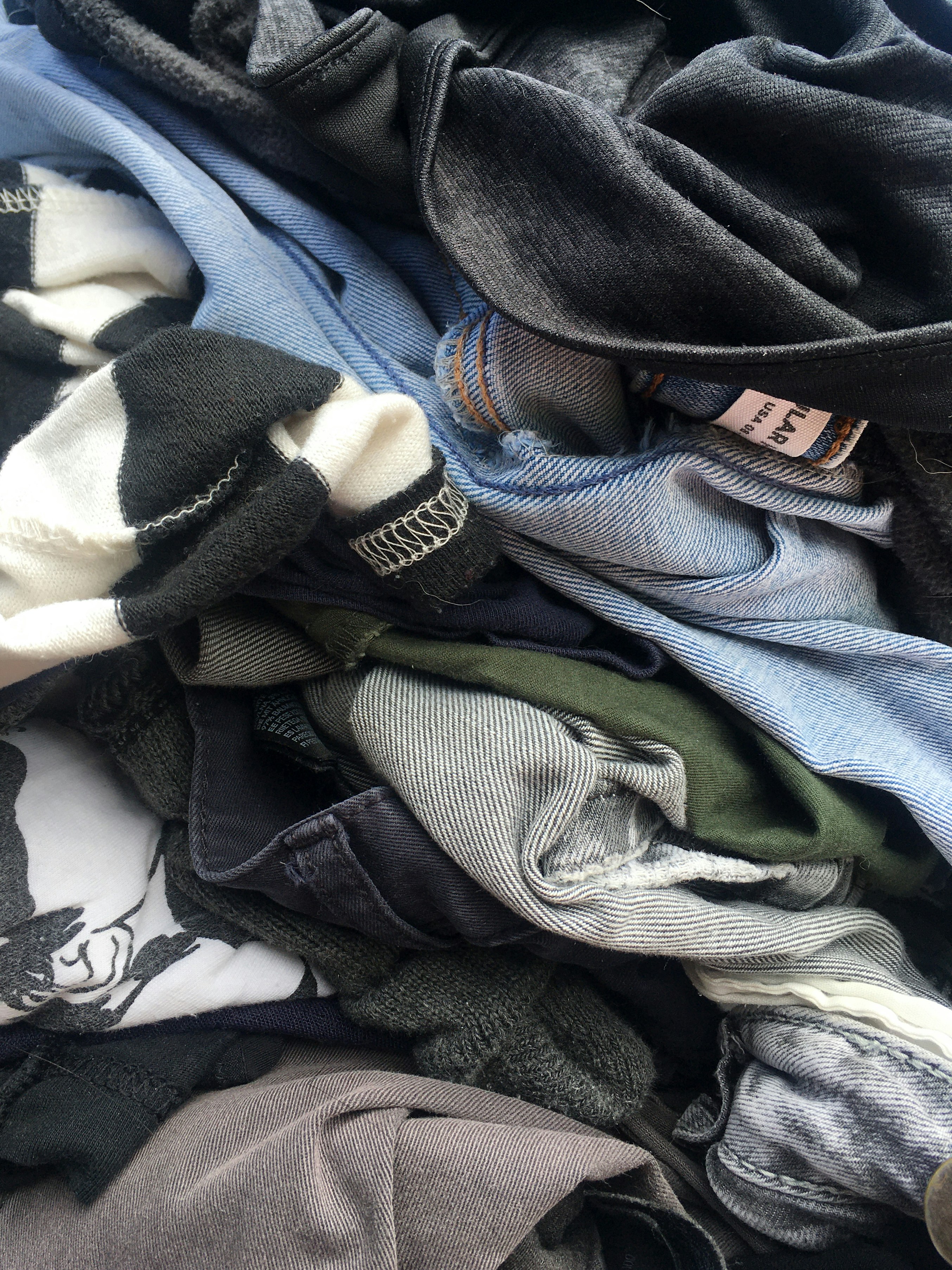 Colour photograph of denim jeans and other cllothes, by Alejo Reinoso on unsplash.