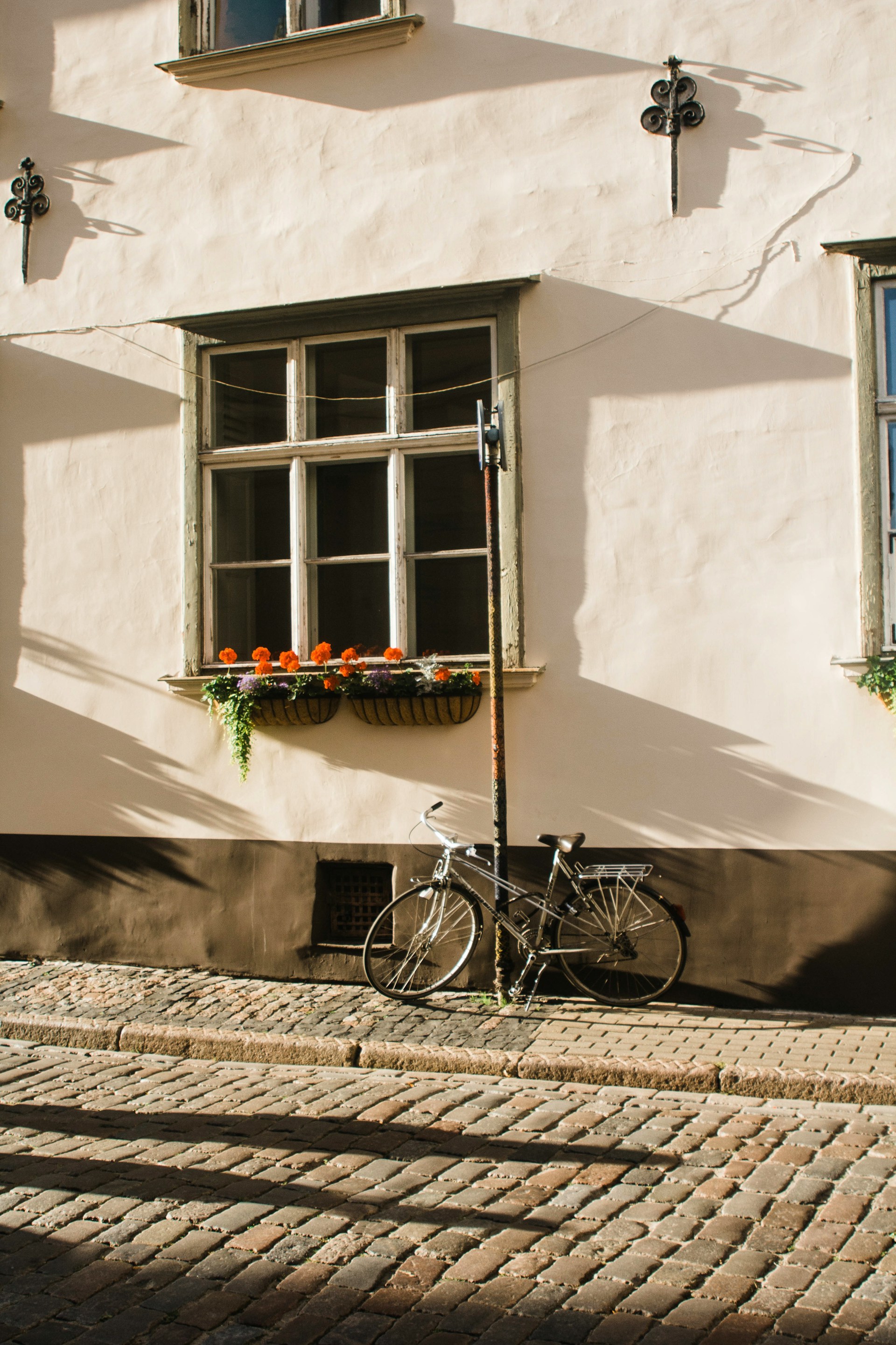 black-city-bike-parked-beside-white-concrete-wall