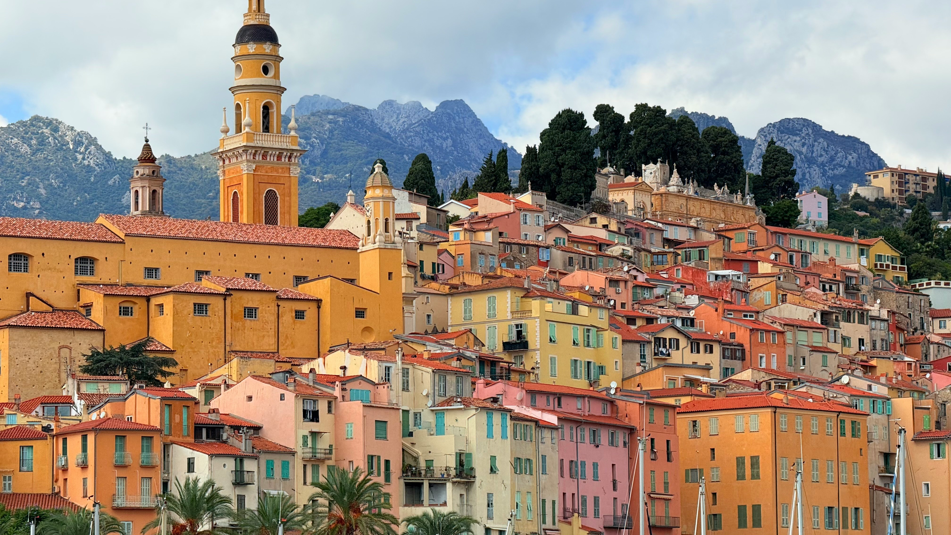 colorful-buildings-on-a-hillside-with-mountains-behind