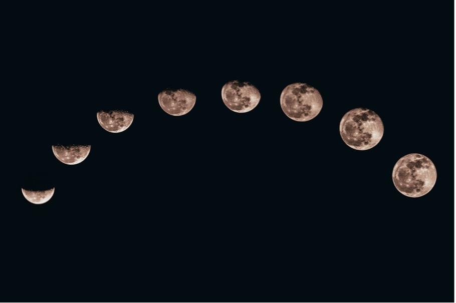 Arc of multiple moon phases progressing from crescent to full against a dark night sky.