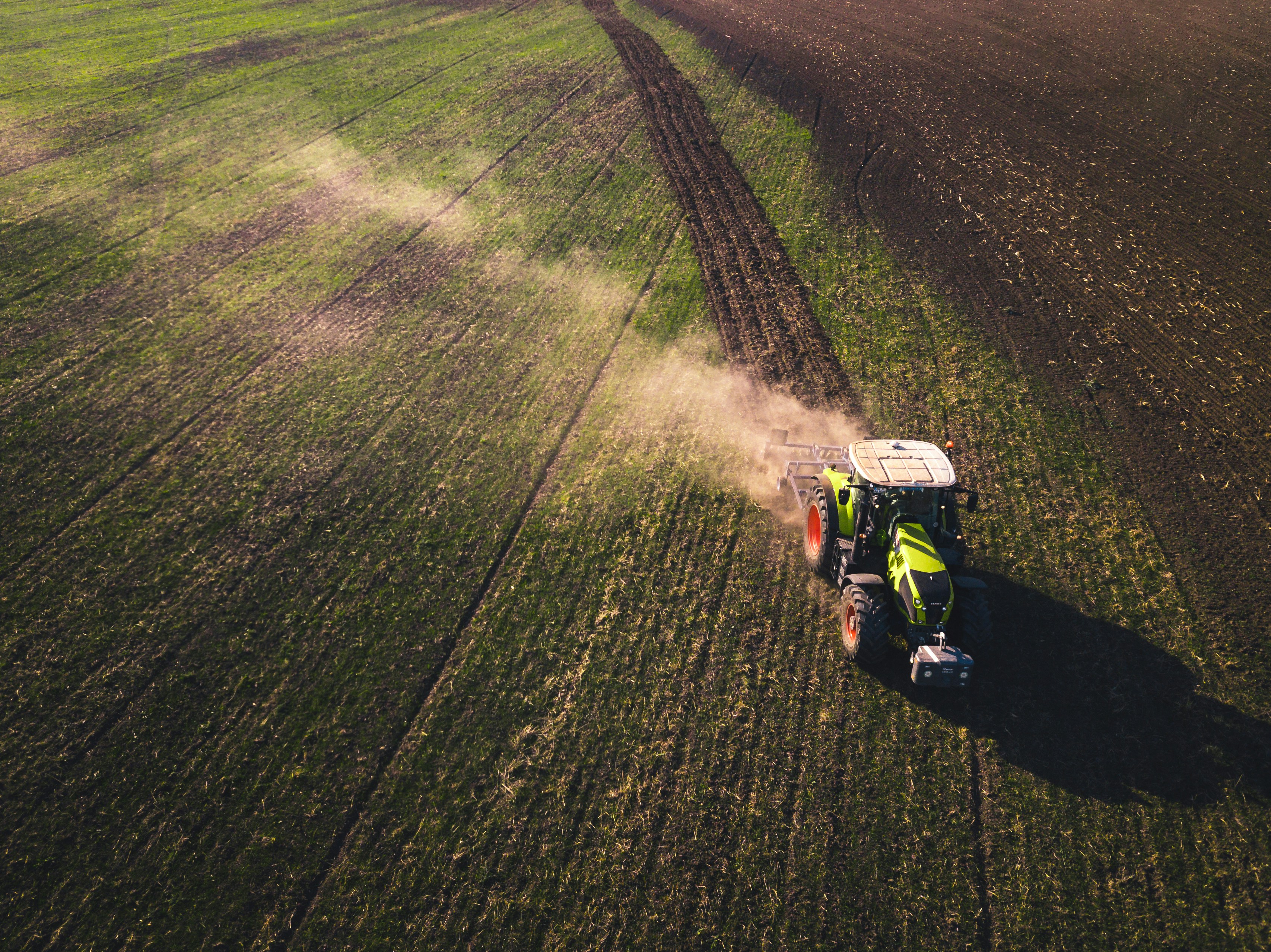 A photo presents a tractor working across a large field.