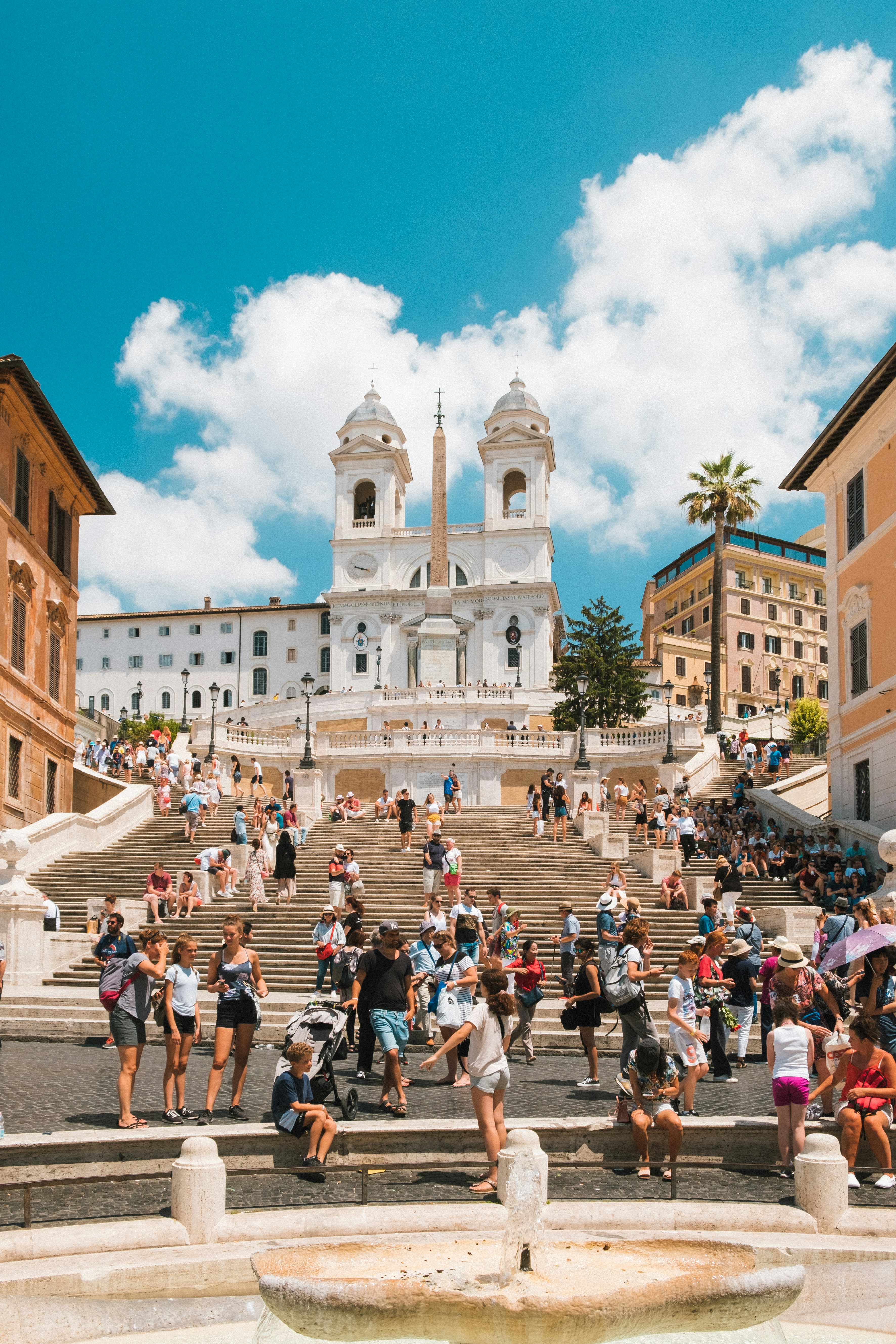 A picture presents tourists gathered on a large historic staircase.