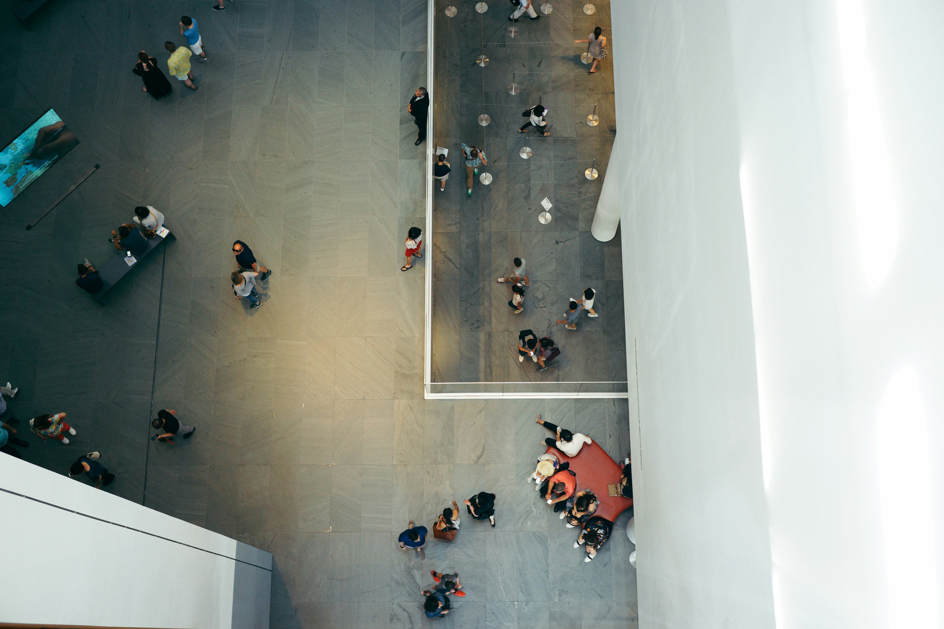 Top-view photography of people beside white concrete building.