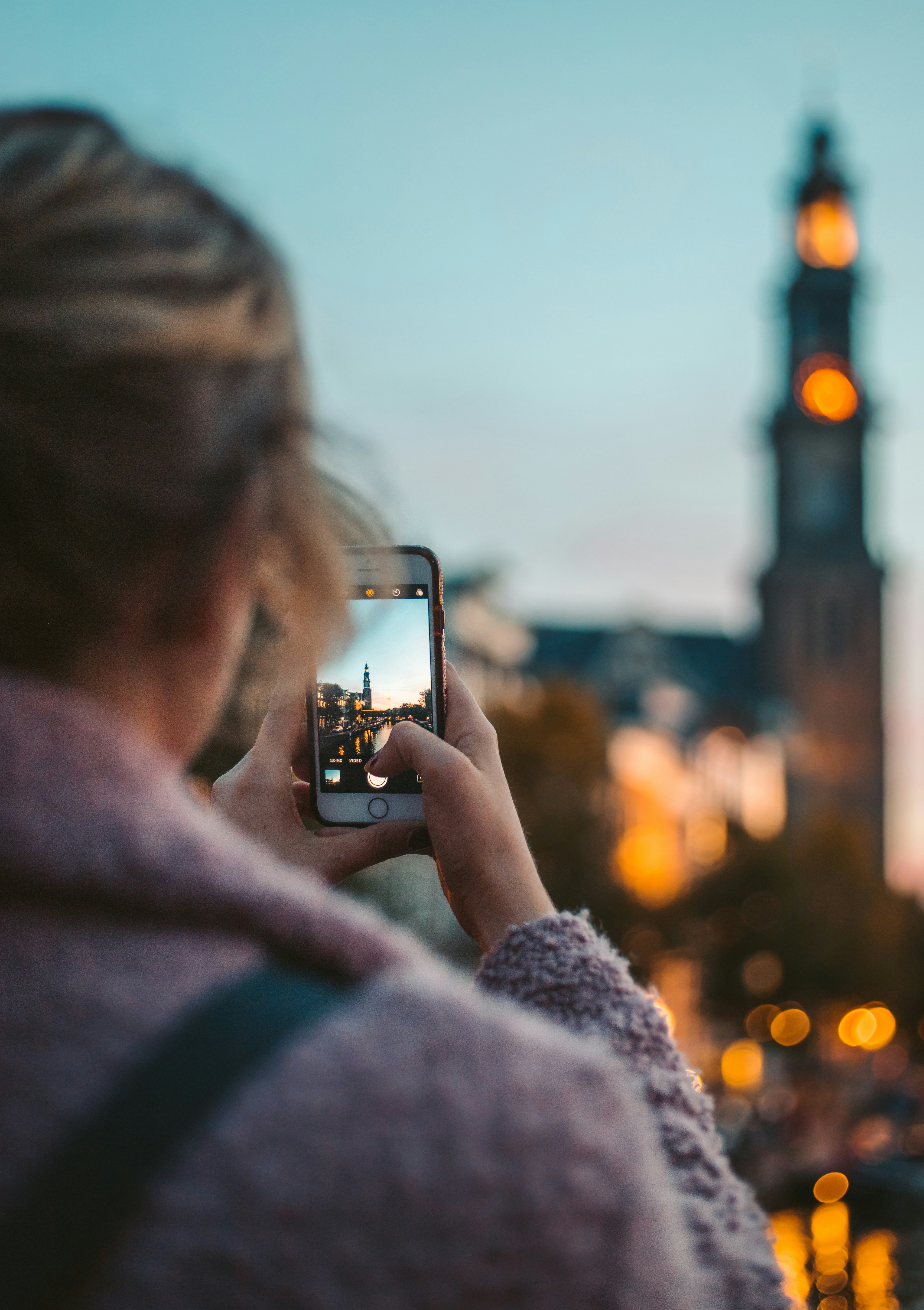 A picture presents a person taking a photo of a city landmark.