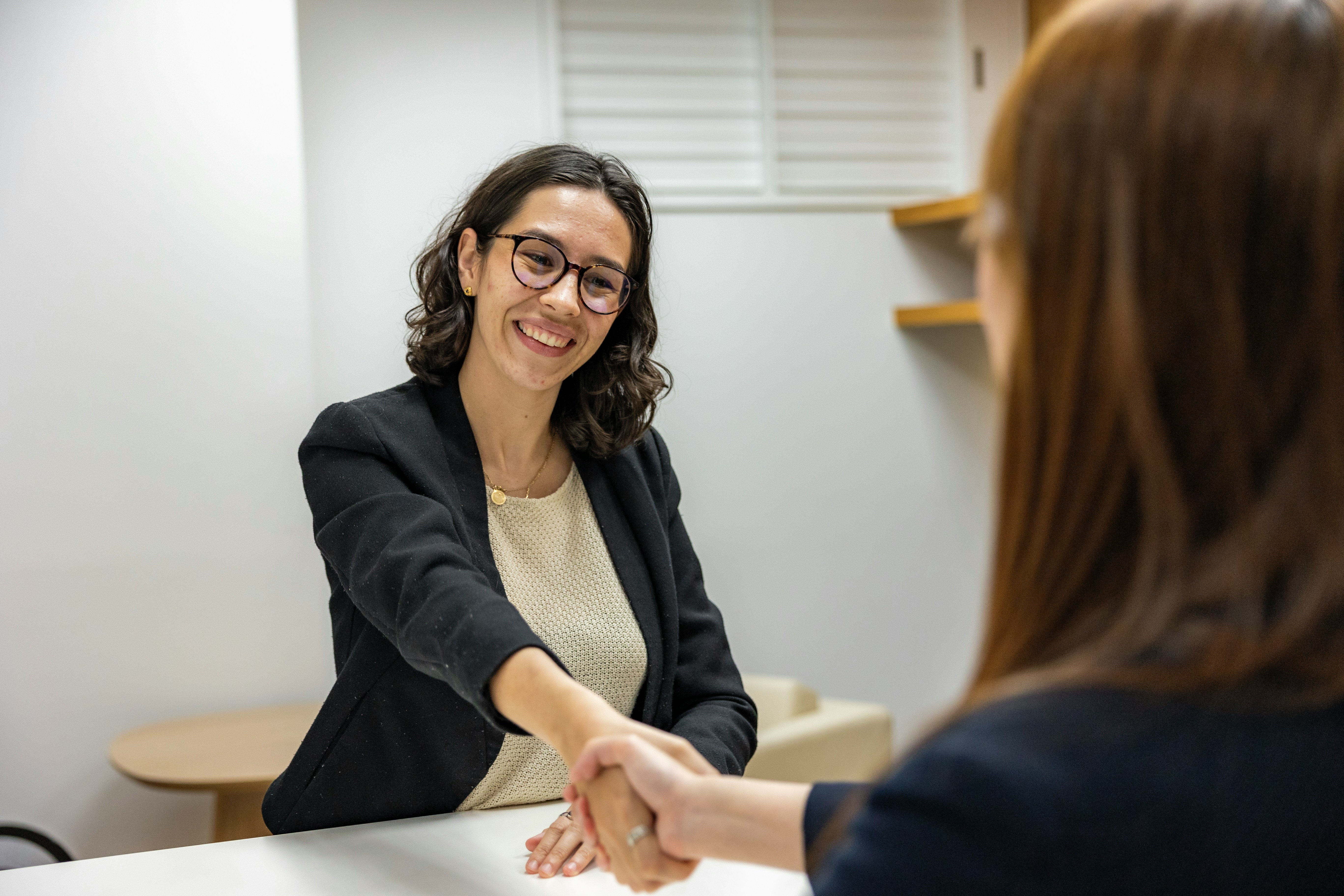 A picture presents two women shaking hands.