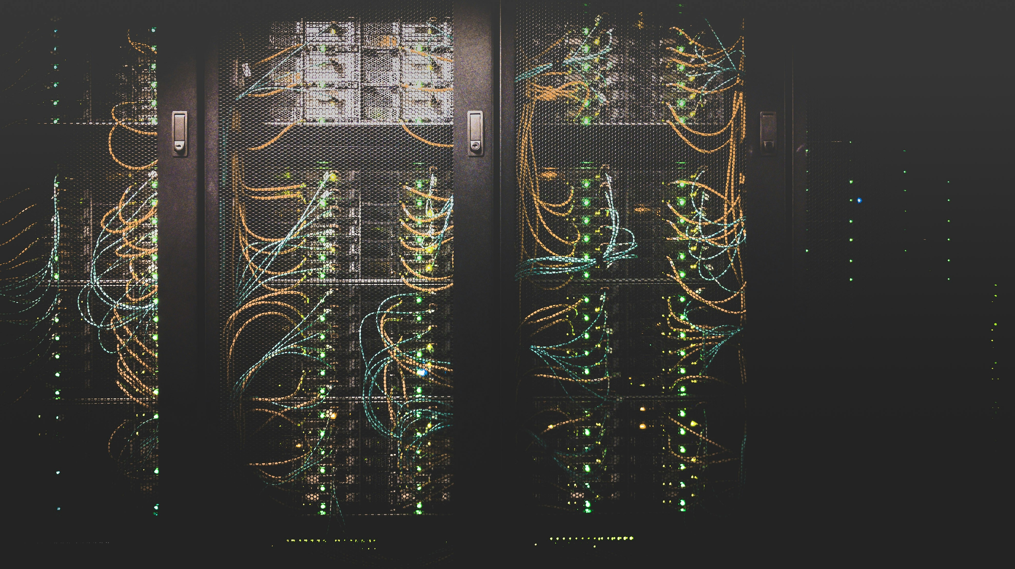 Photo presenting server racks with illuminated network cables and data center equipment.