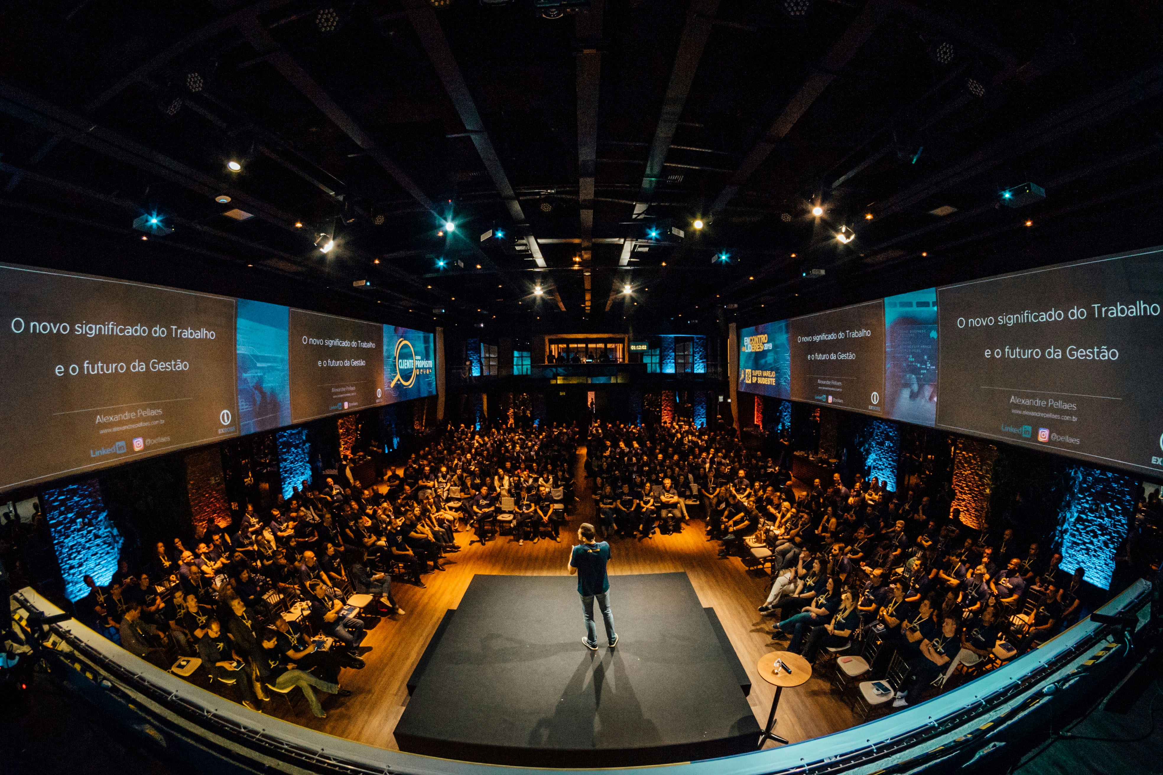 The photo presents an audience attending a conference.