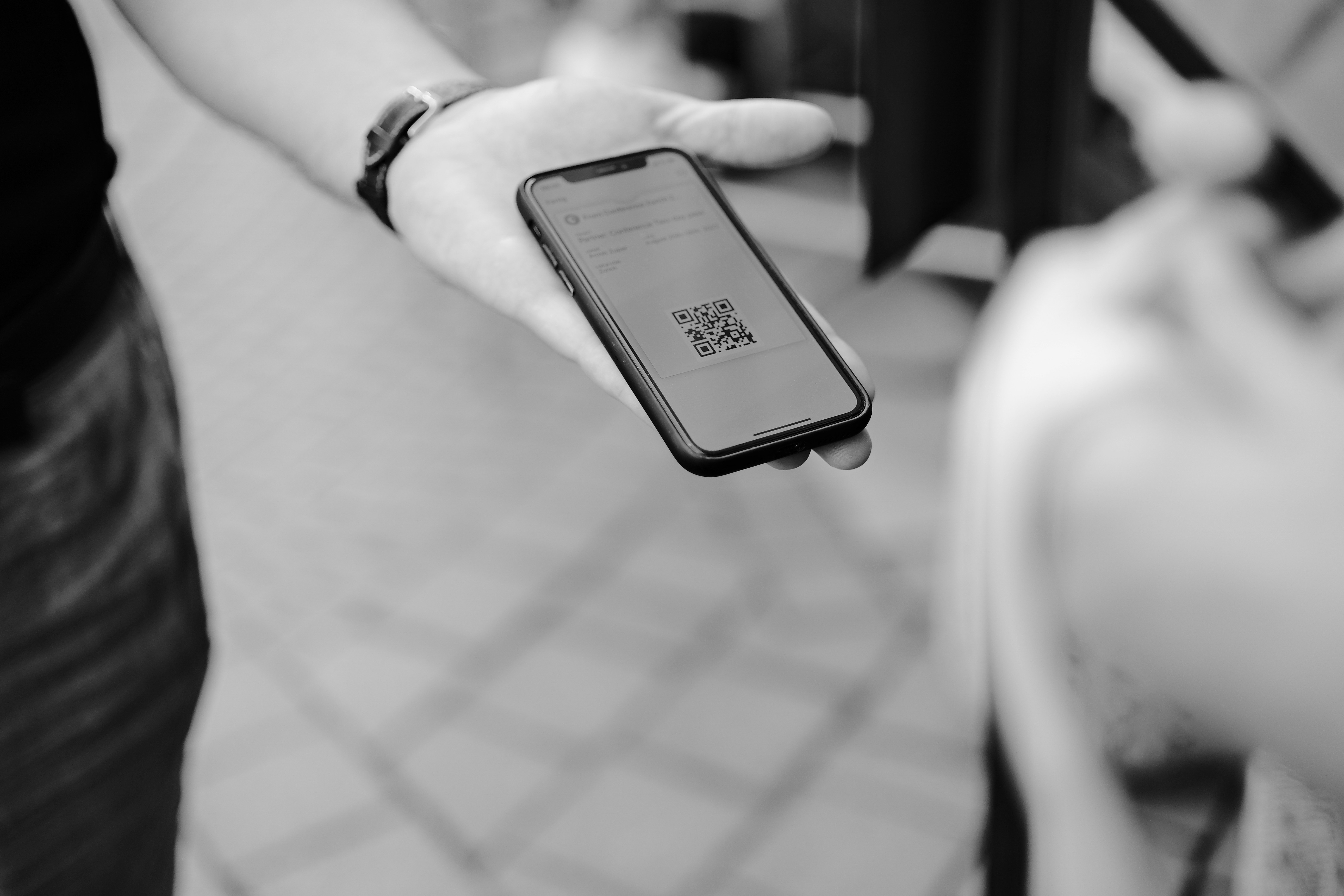 A person holding a cell phone which has QR code 