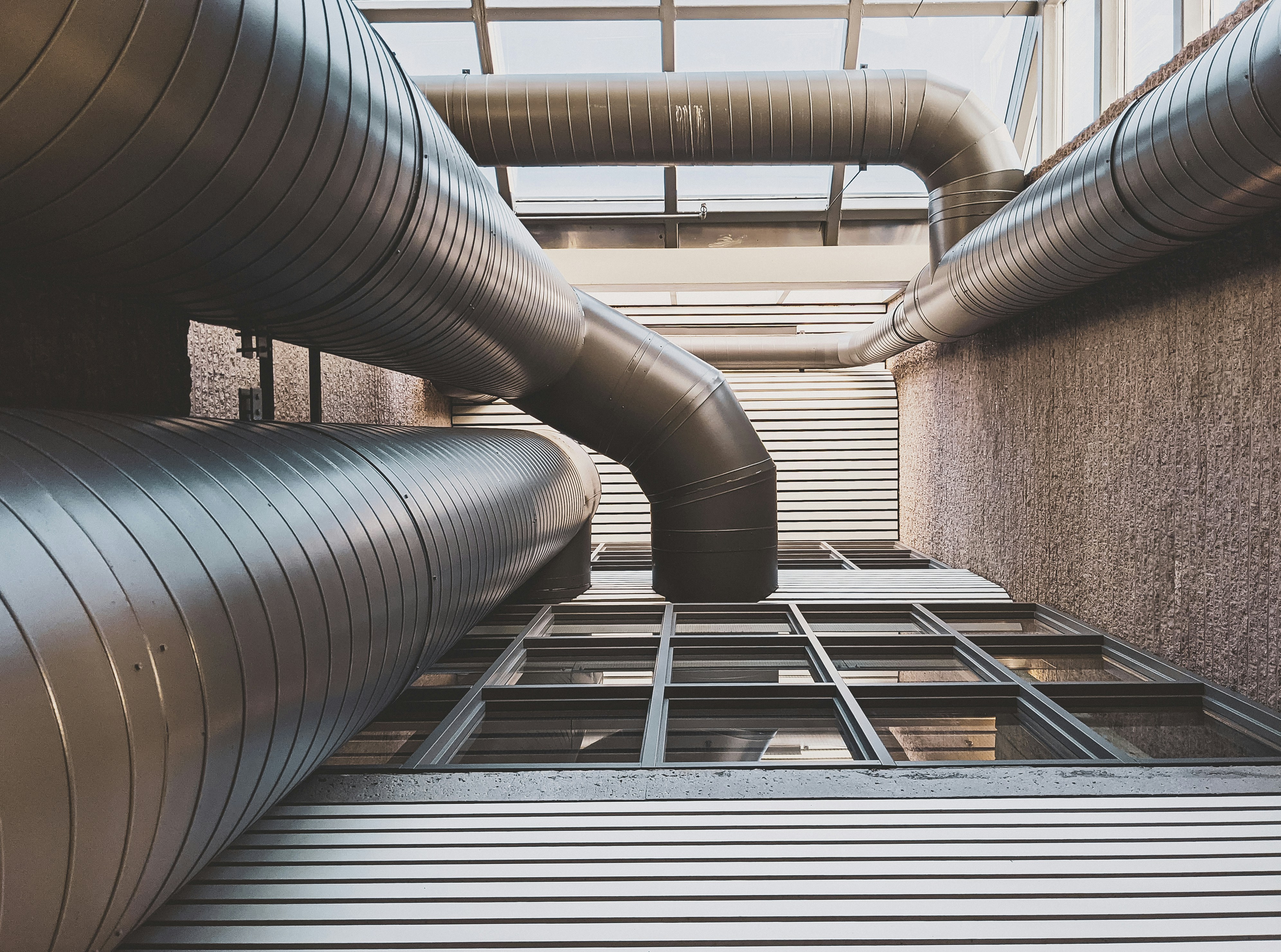 The image depicts large ventilation ducts integrated within a modern building.