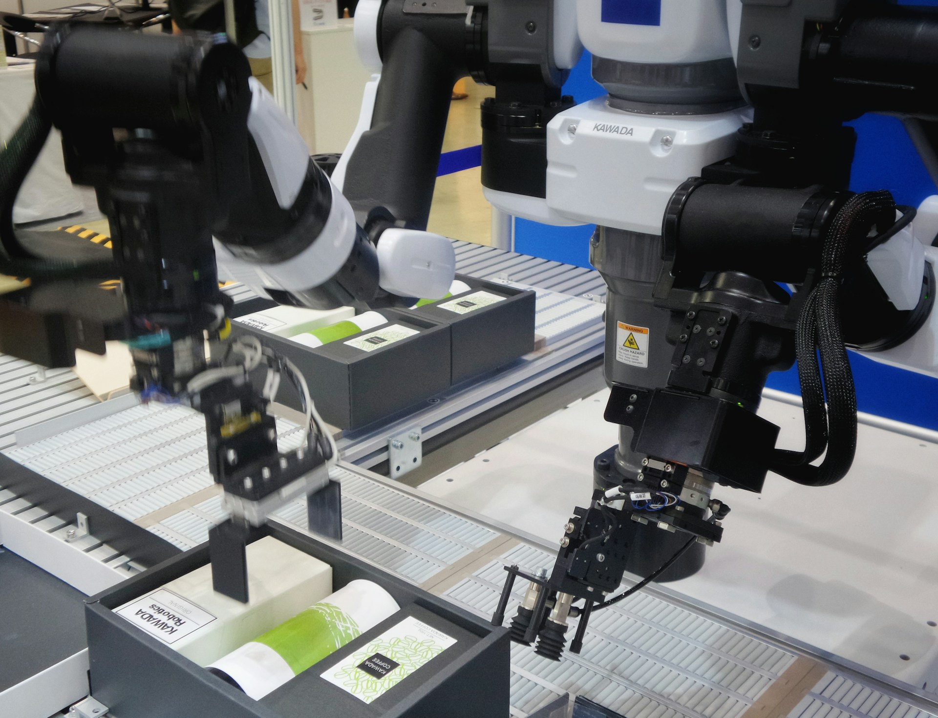 The photo presents robotic arms handling and packaging products on an automated production line.