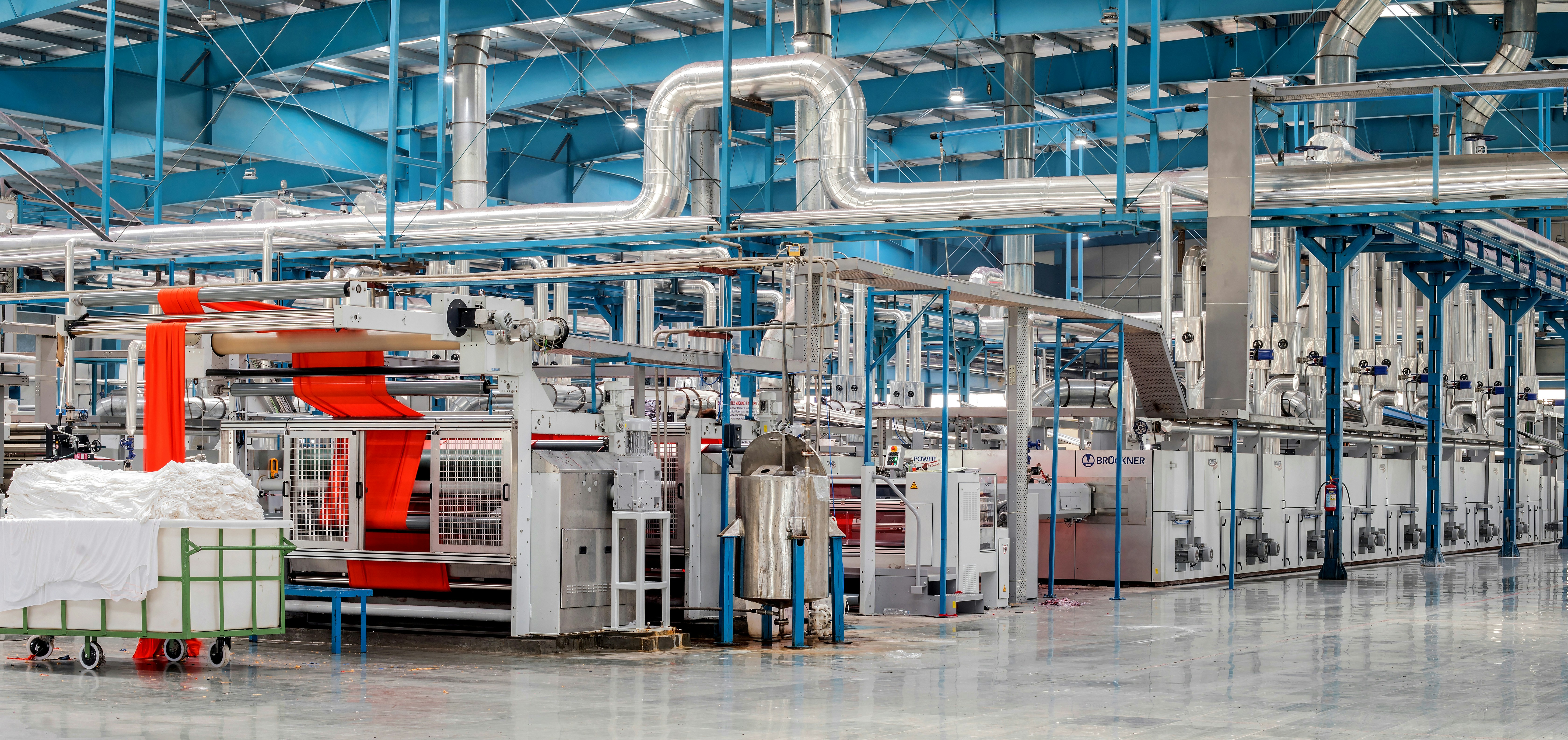 Modern textile manufacturing facility with industrial machinery, fabric processing equipment and production lines