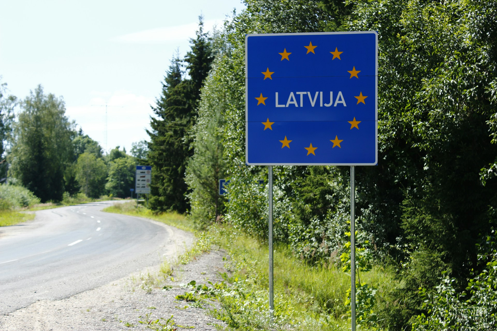 The photo presents a road sign marking the border of Latvia and the European Union.