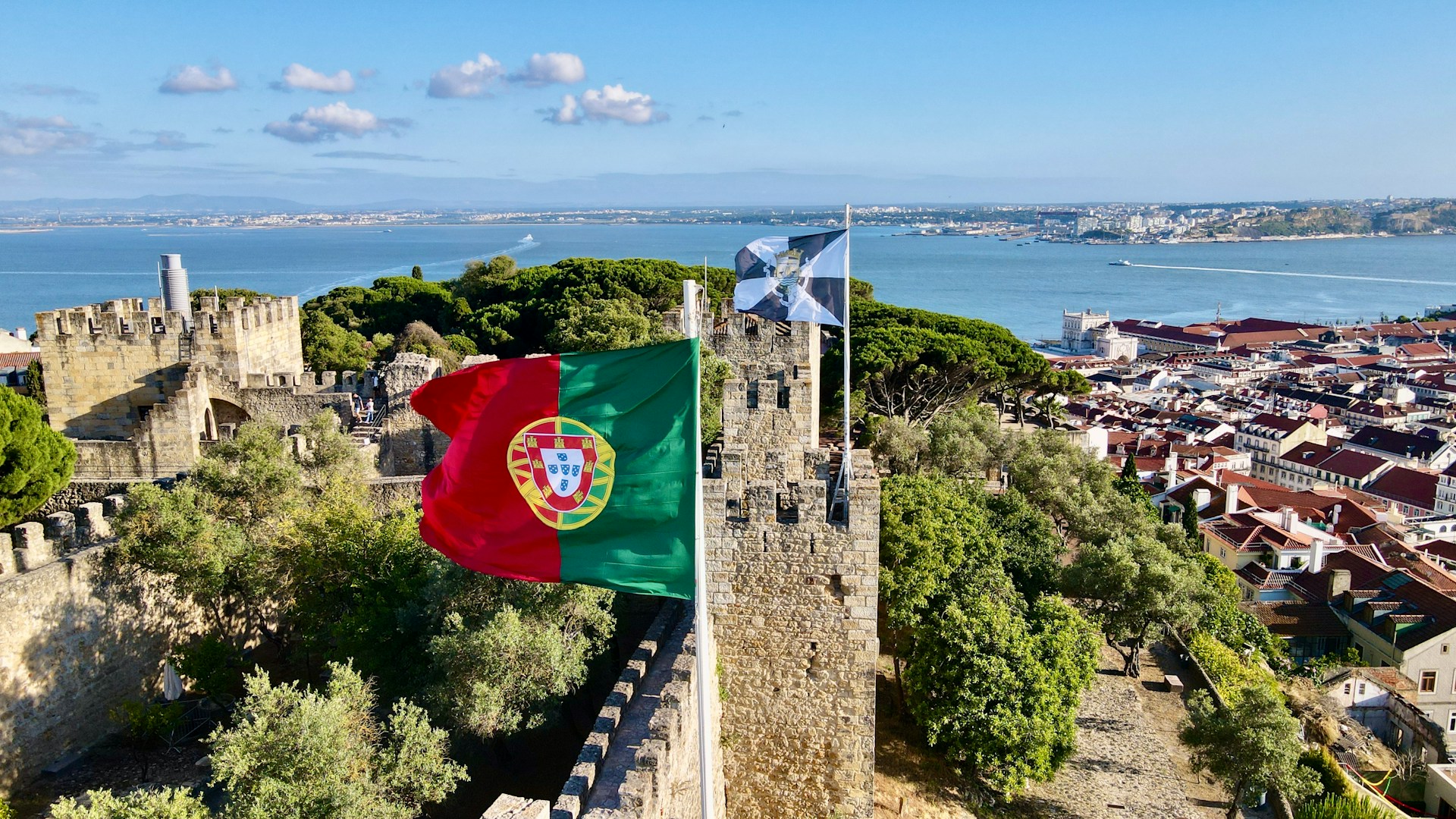 The photo presents the Portuguese flag with Lisbon in the background.