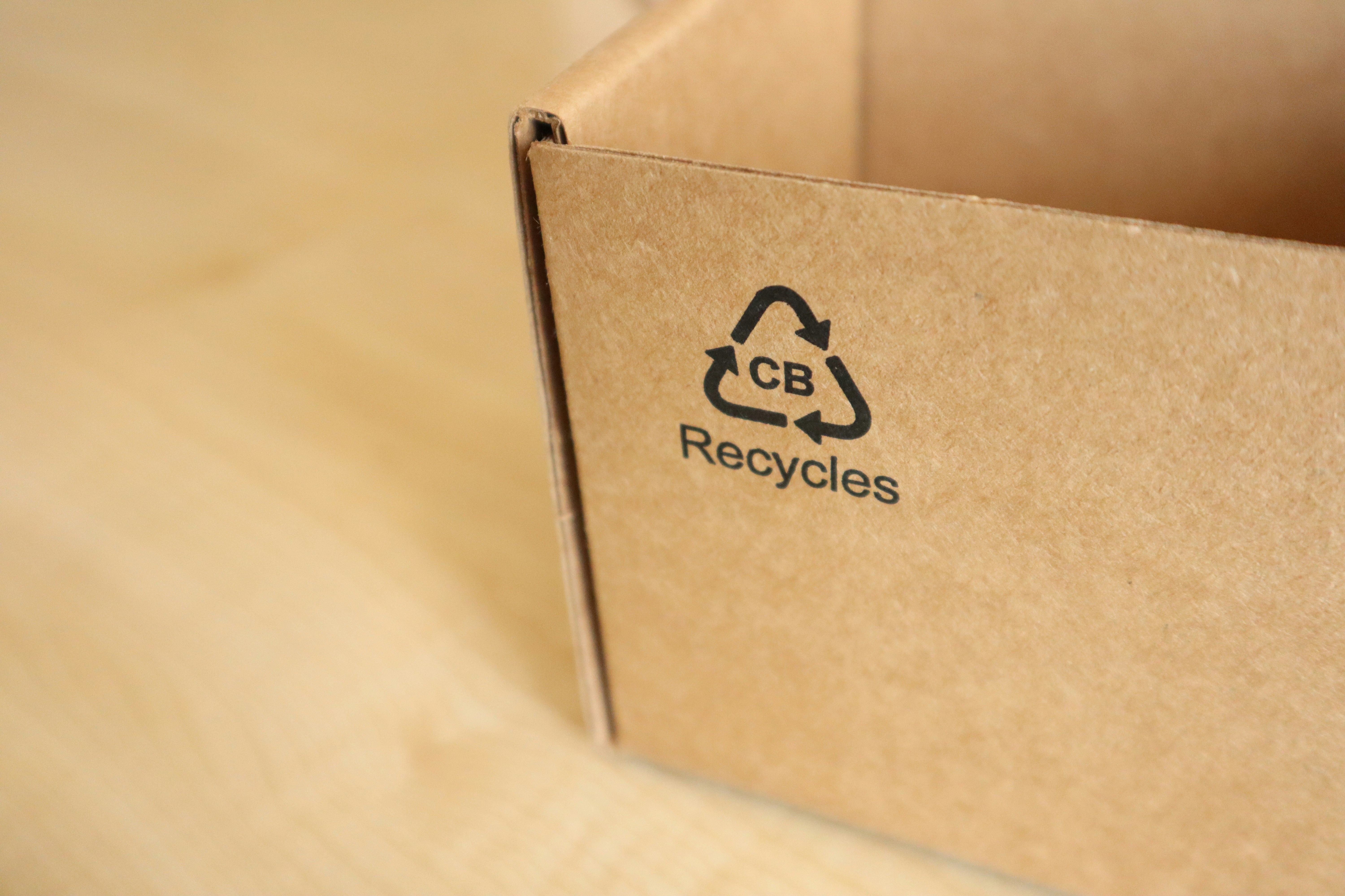 The photo presents a cardboard box with a recycling symbol.