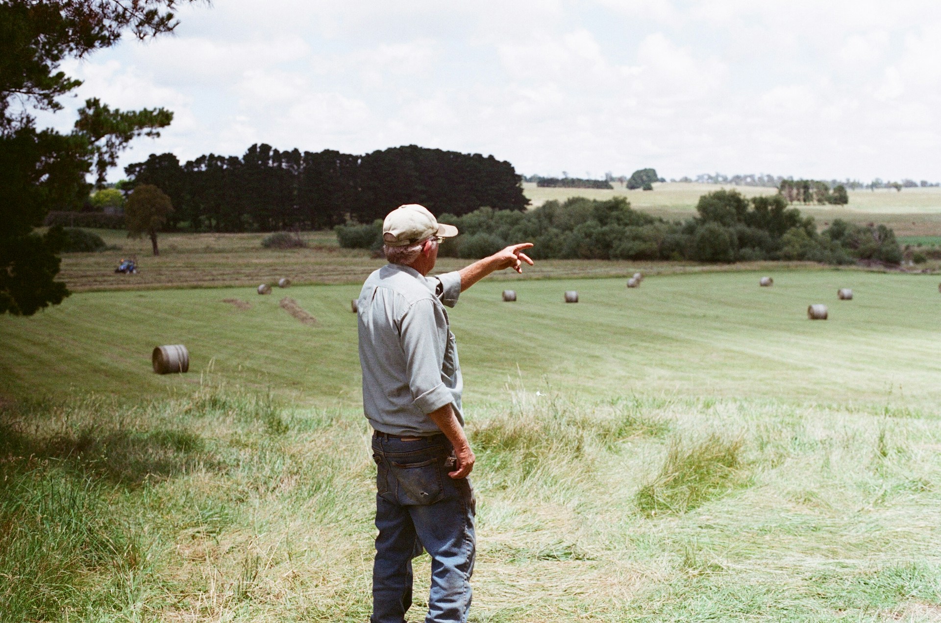 The photo presents a farmer standing in a field.