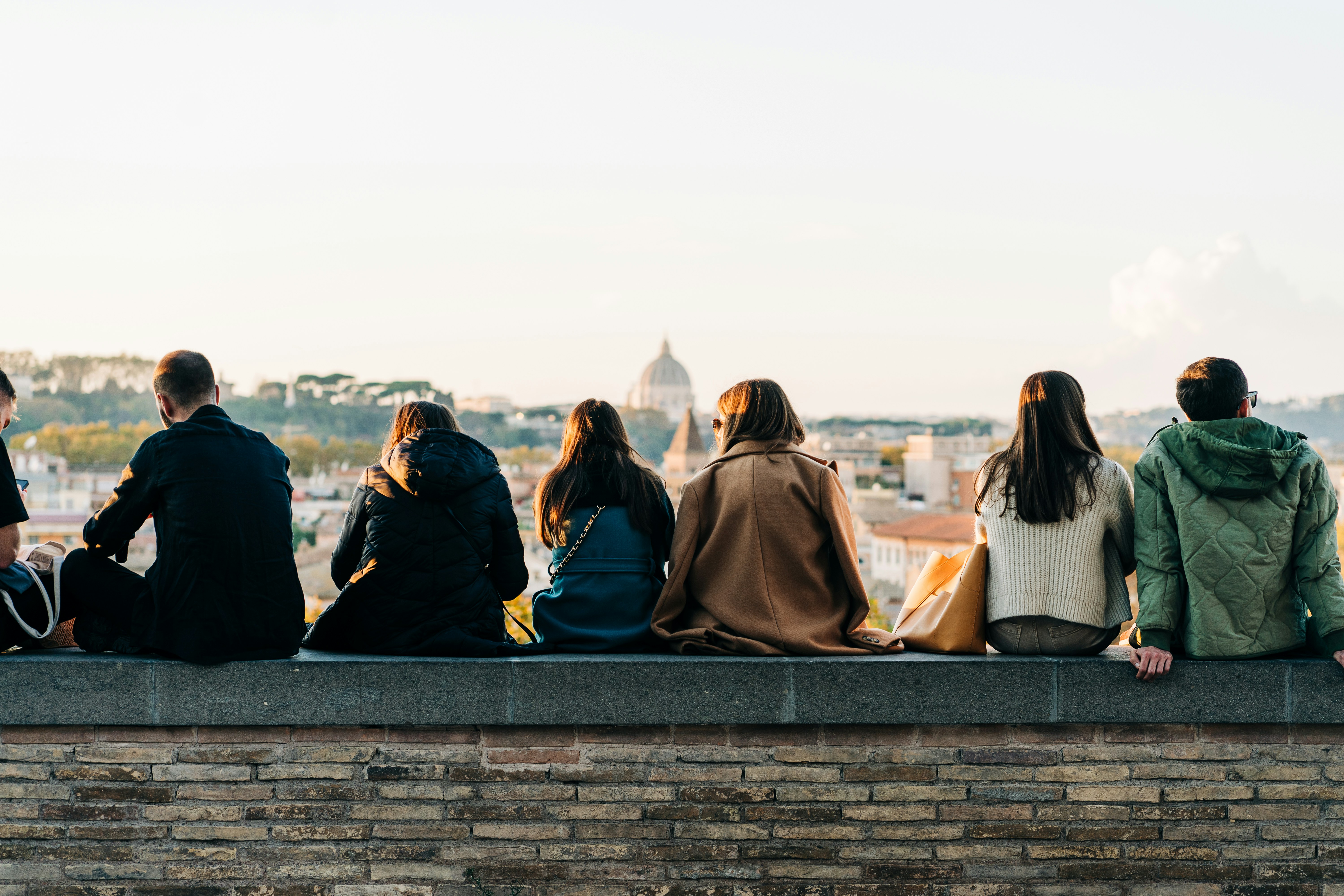 The photo shows tourists and locals mingle at sunset in Giardino degli Aranci in Rome, Italy