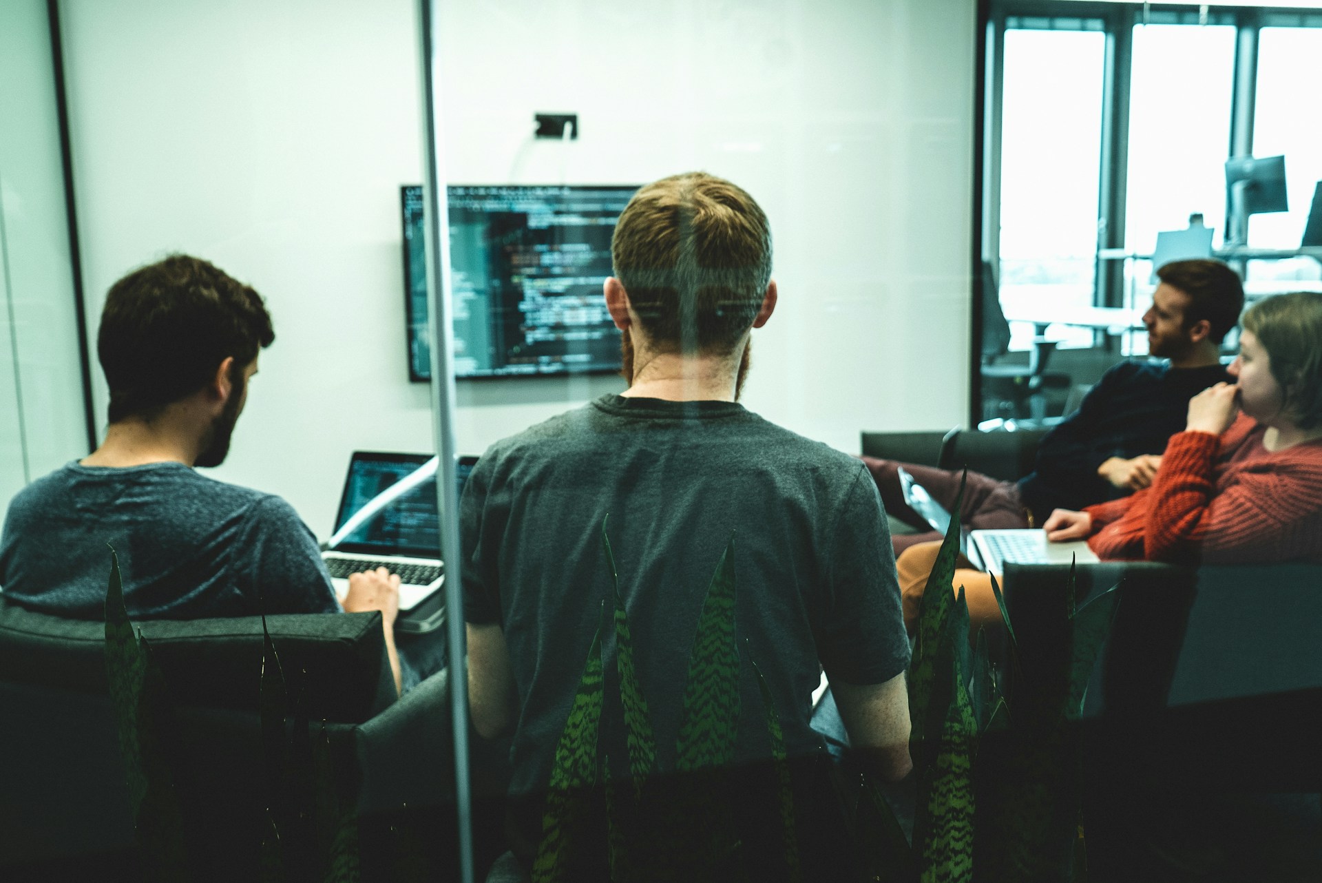 The photo presents a team working on computers.