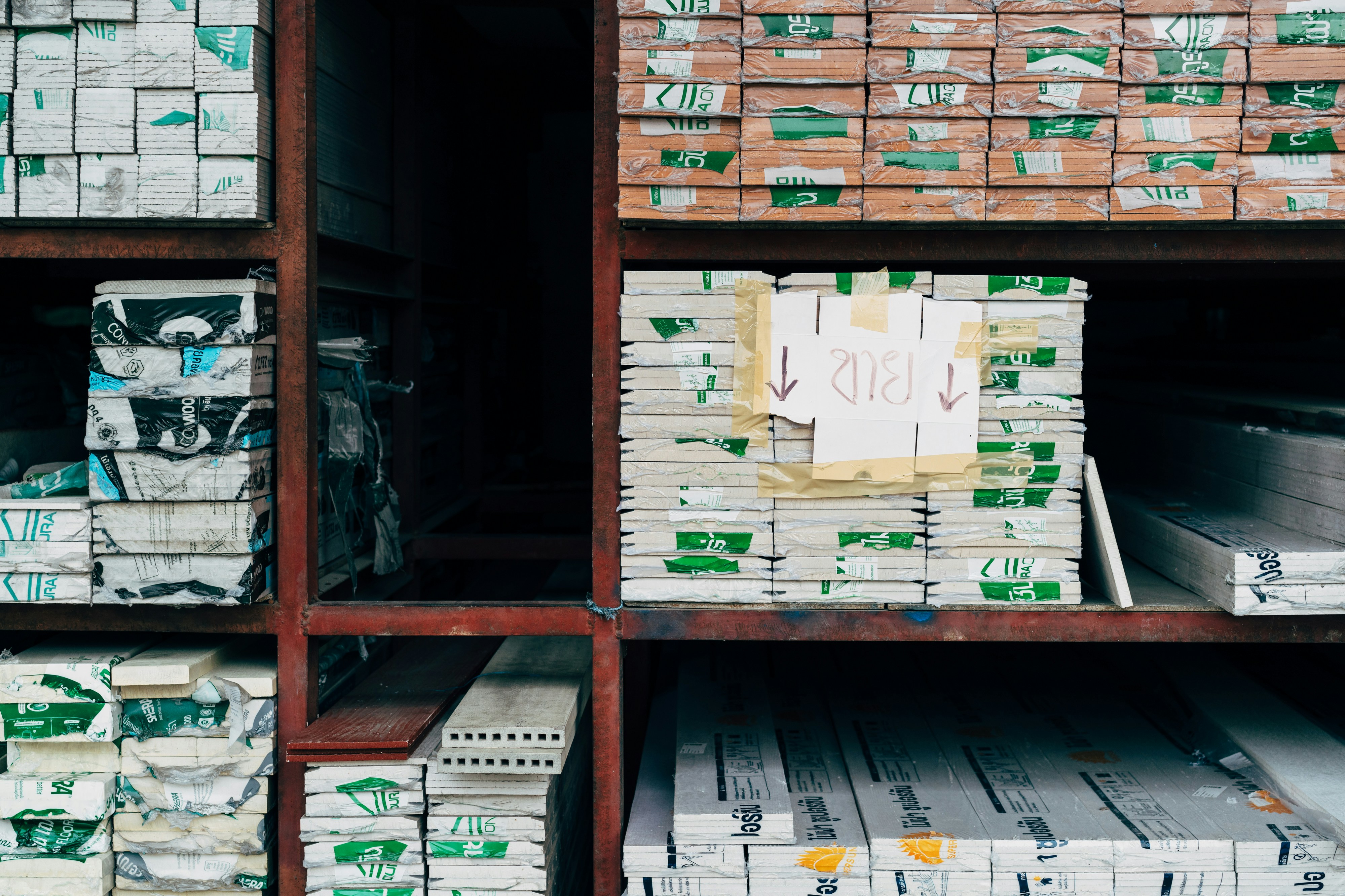 The picture shows stacks of construction and insulation materials neatly stored on industrial warehouse shelving.