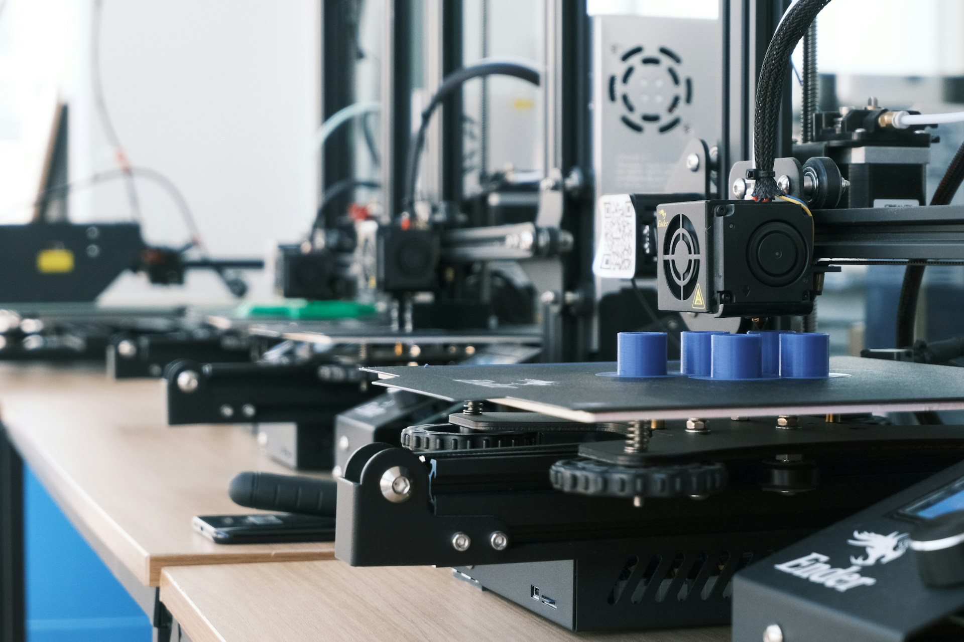 The photo presents several 3D printers.