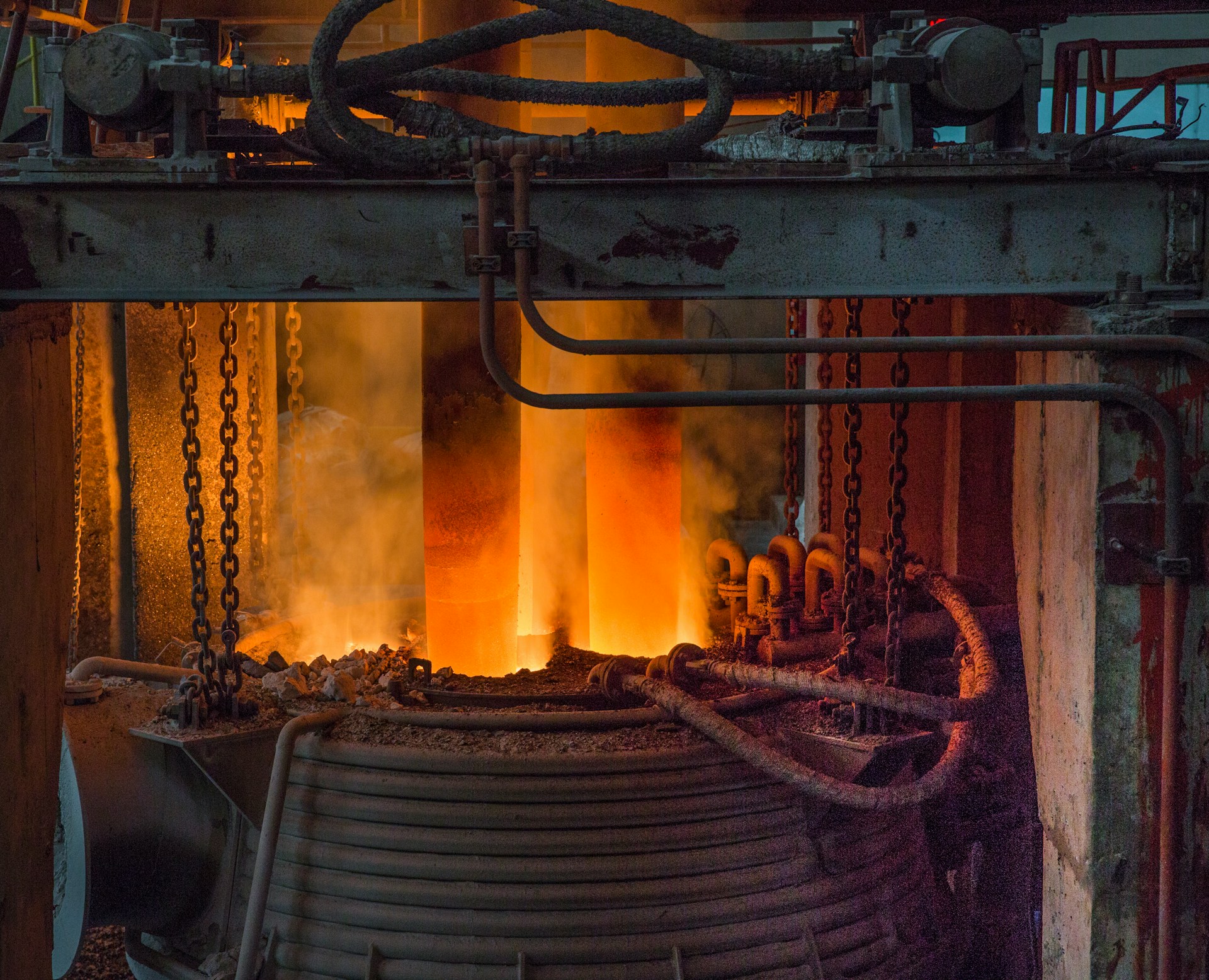 The photo shows a large, red-hot metal object with flames emanating from it.