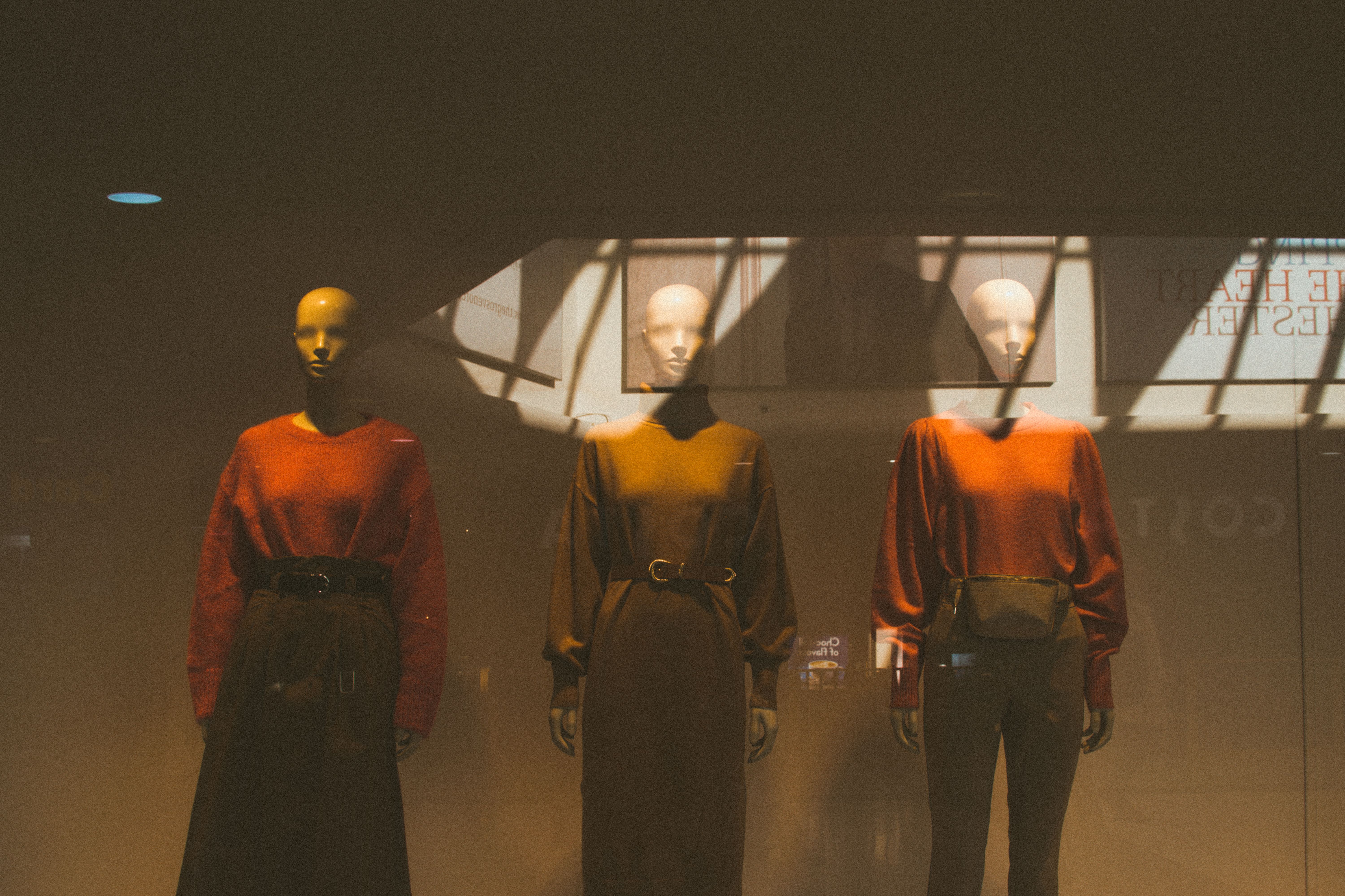 A stylish window display featuring mannequins dressed in autumn fashion attire.