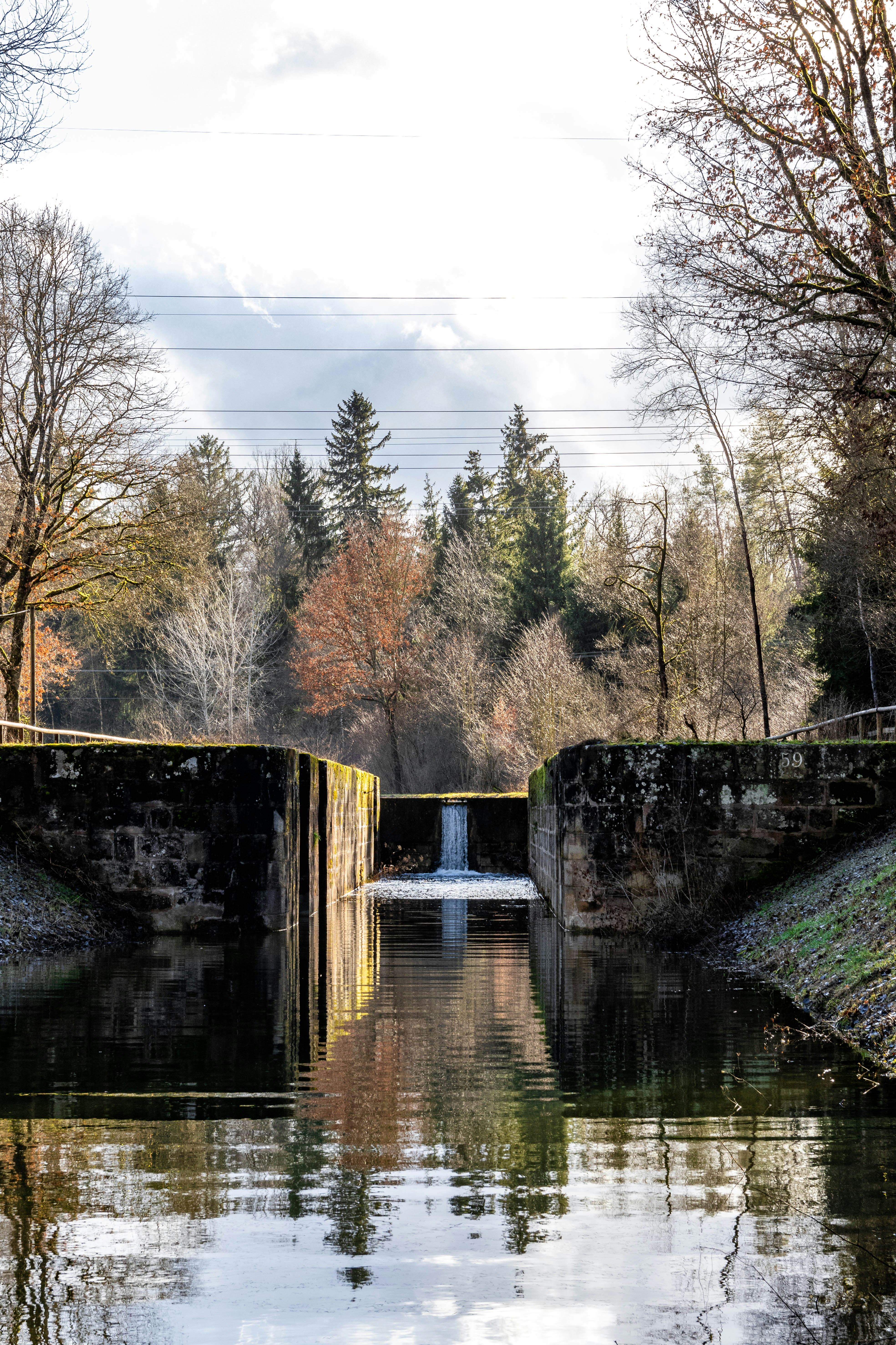 The picture describes a concrete water management structure with large openings above a body of water.