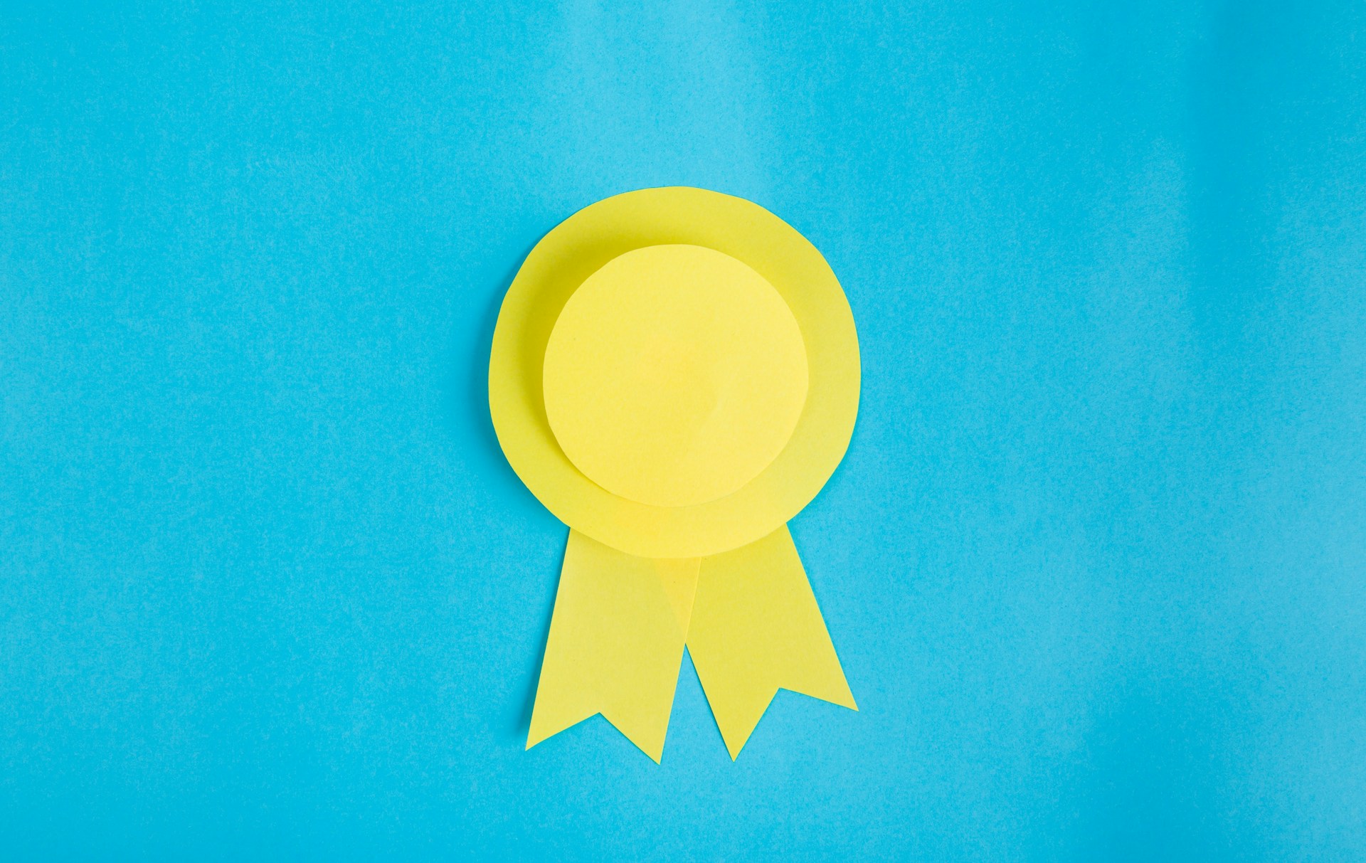 The photo presents a yellow award ribbon on a blue background.