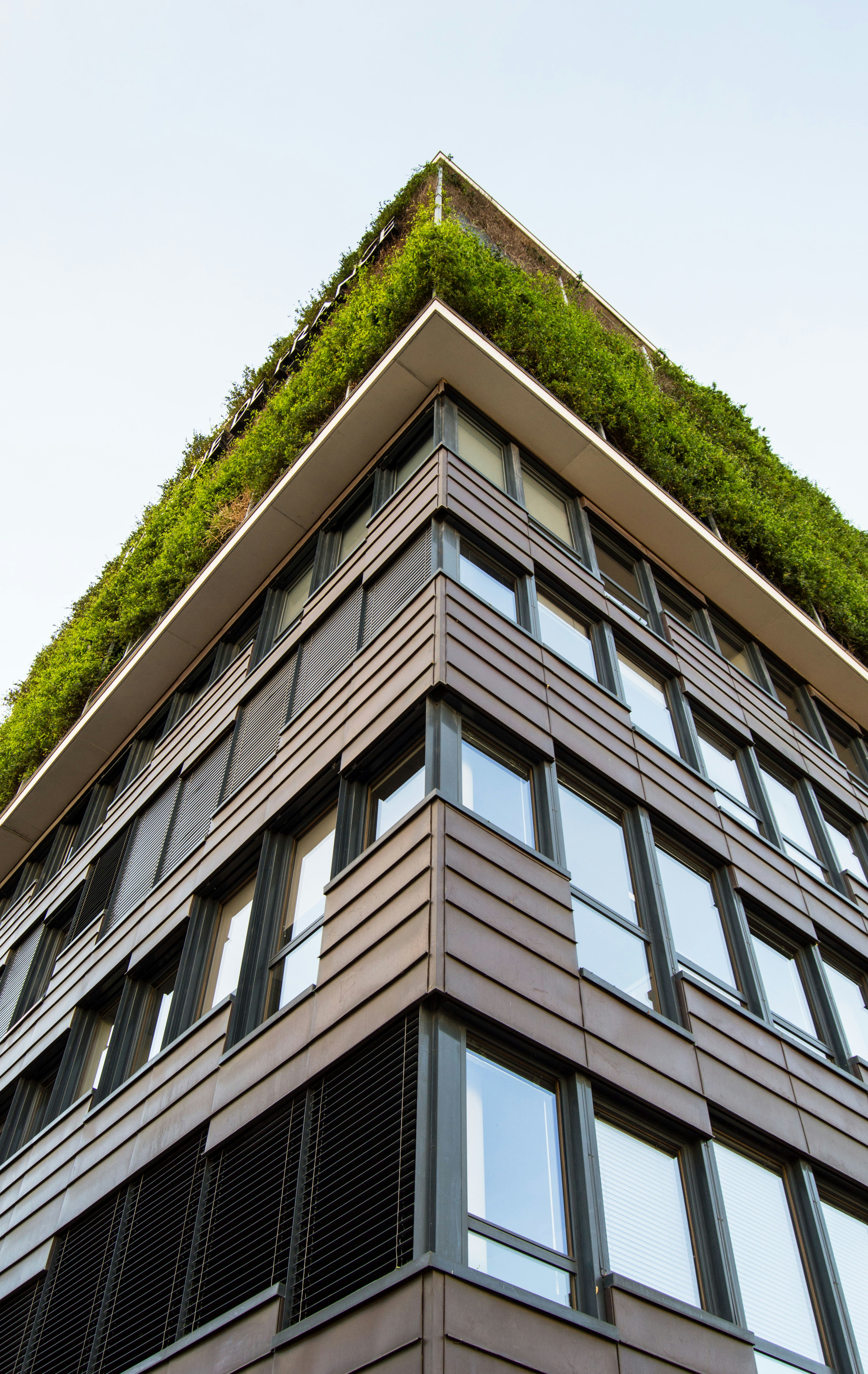 This picture shows a modern multi-story building photographed from a low-angle perspective, emphasizing its height and architectural design.