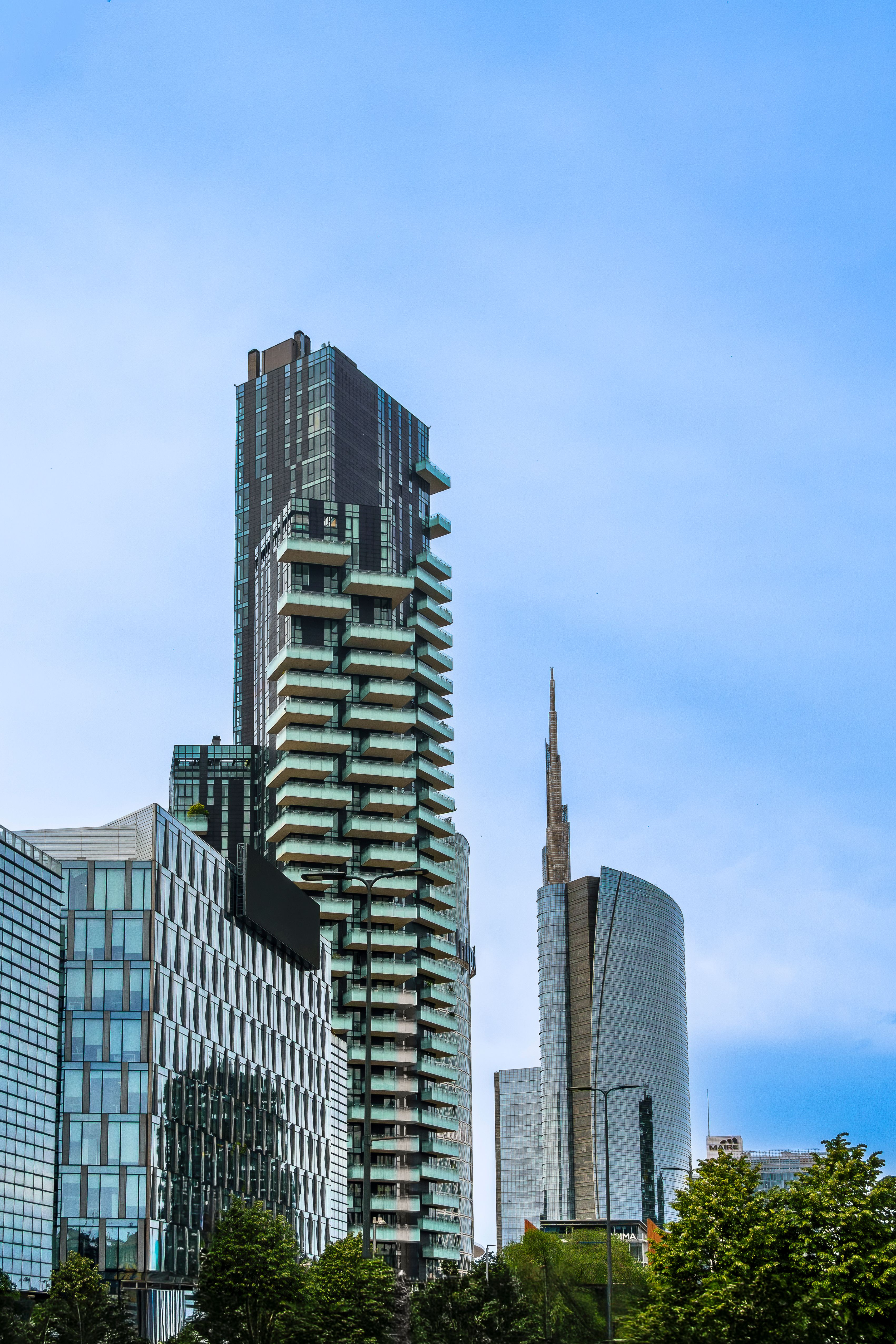The picture shows a modern urban district in Milan, Italy, characterized by contemporary high-rise architecture and extensive glass façades.
