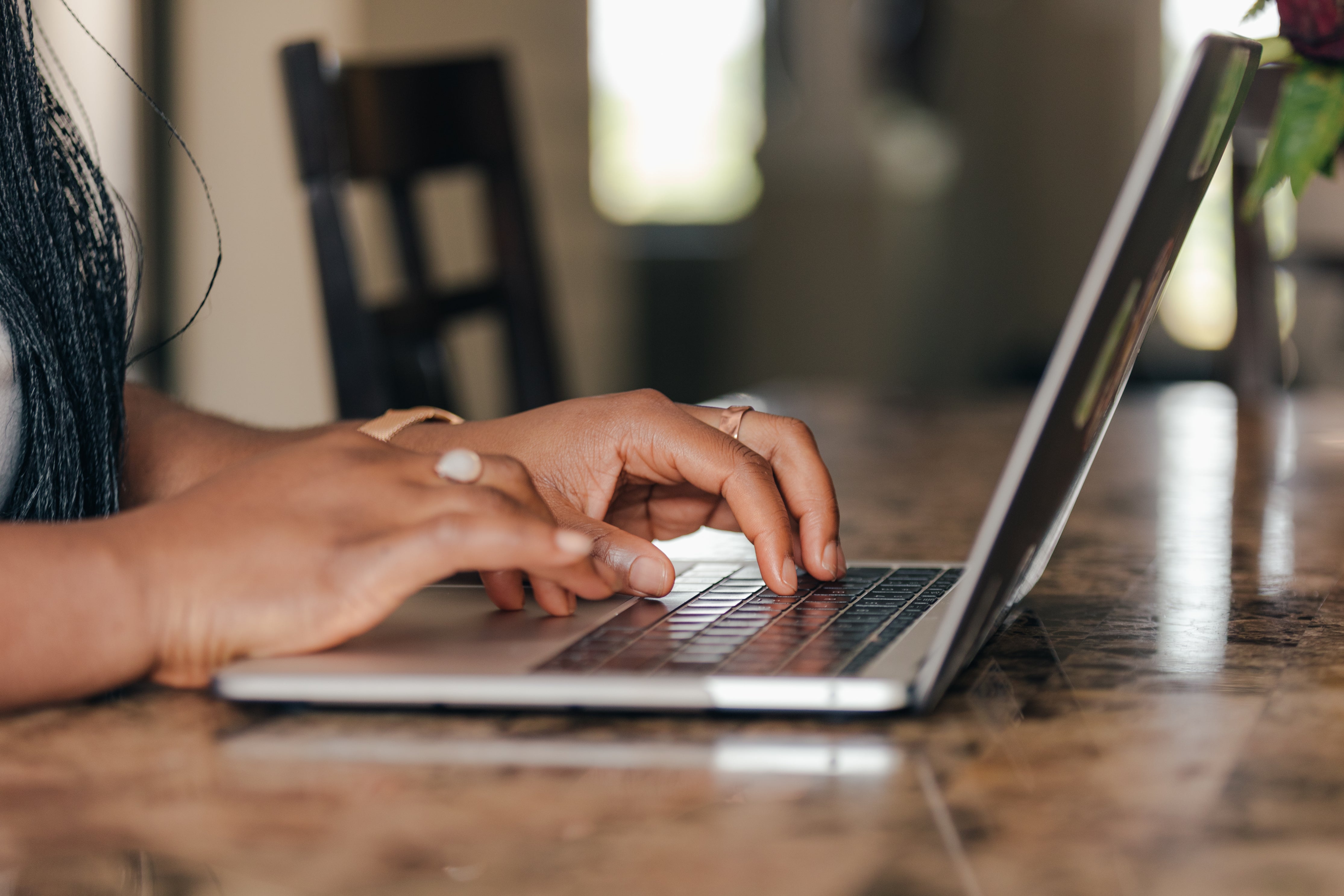 An illustrative photo of hands typing away on a laptop.