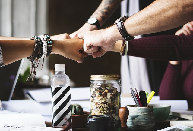 An illustrative photo of a group of people join hands in a collaborative gesture