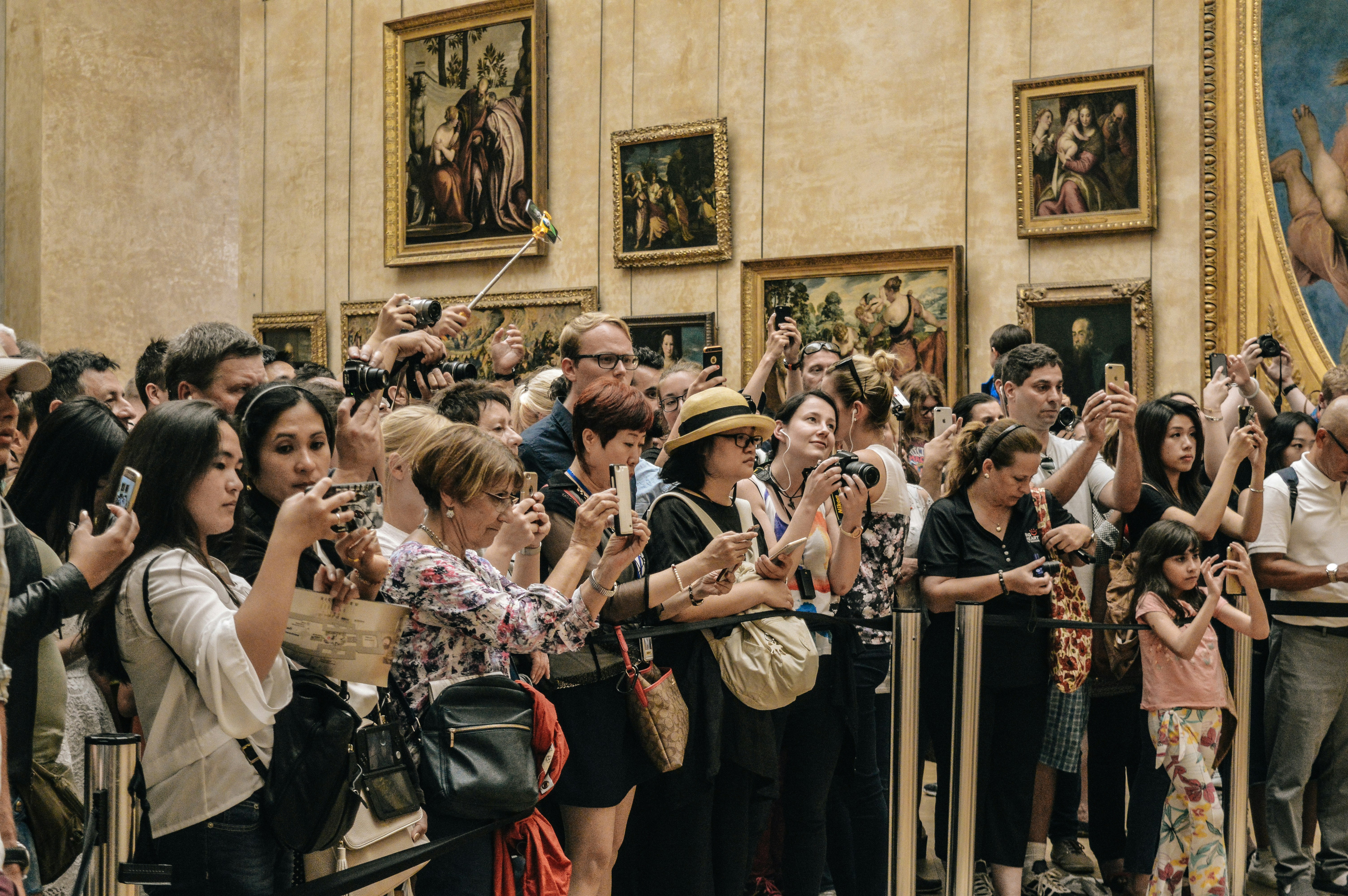 An illustrative photo of crowd of people taking pictures in the Louvre museum