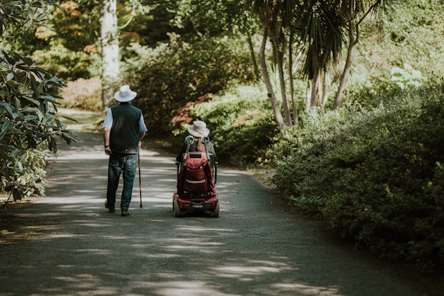 An illustrative photo of two people walking through a lush garden or park.