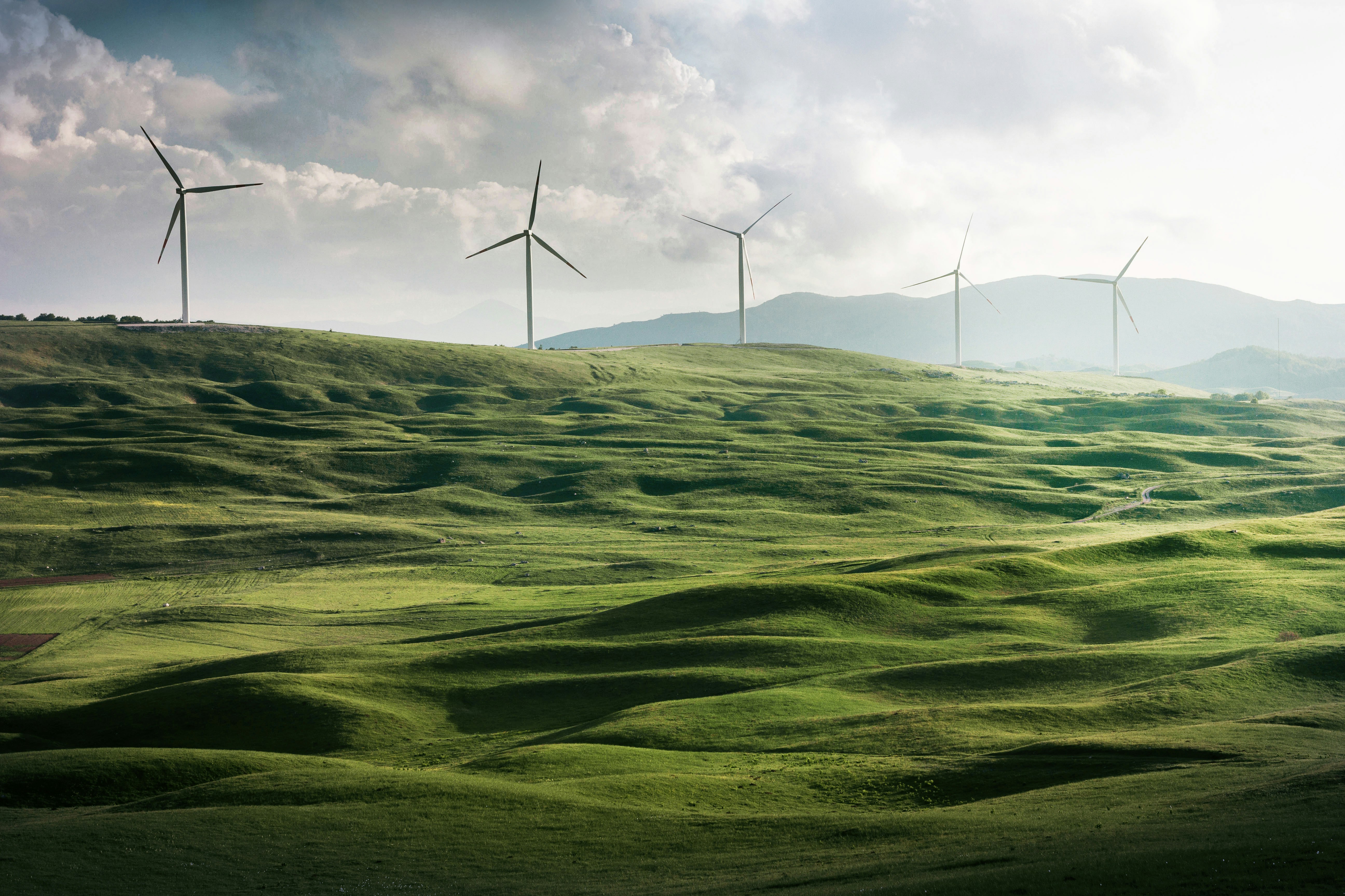 An illustrative photo of wind turbine surrounded by grass.