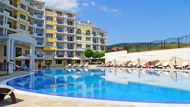 An illustrative photo of a large outdoor swimming pool, overlooked by a building in Bulgaria