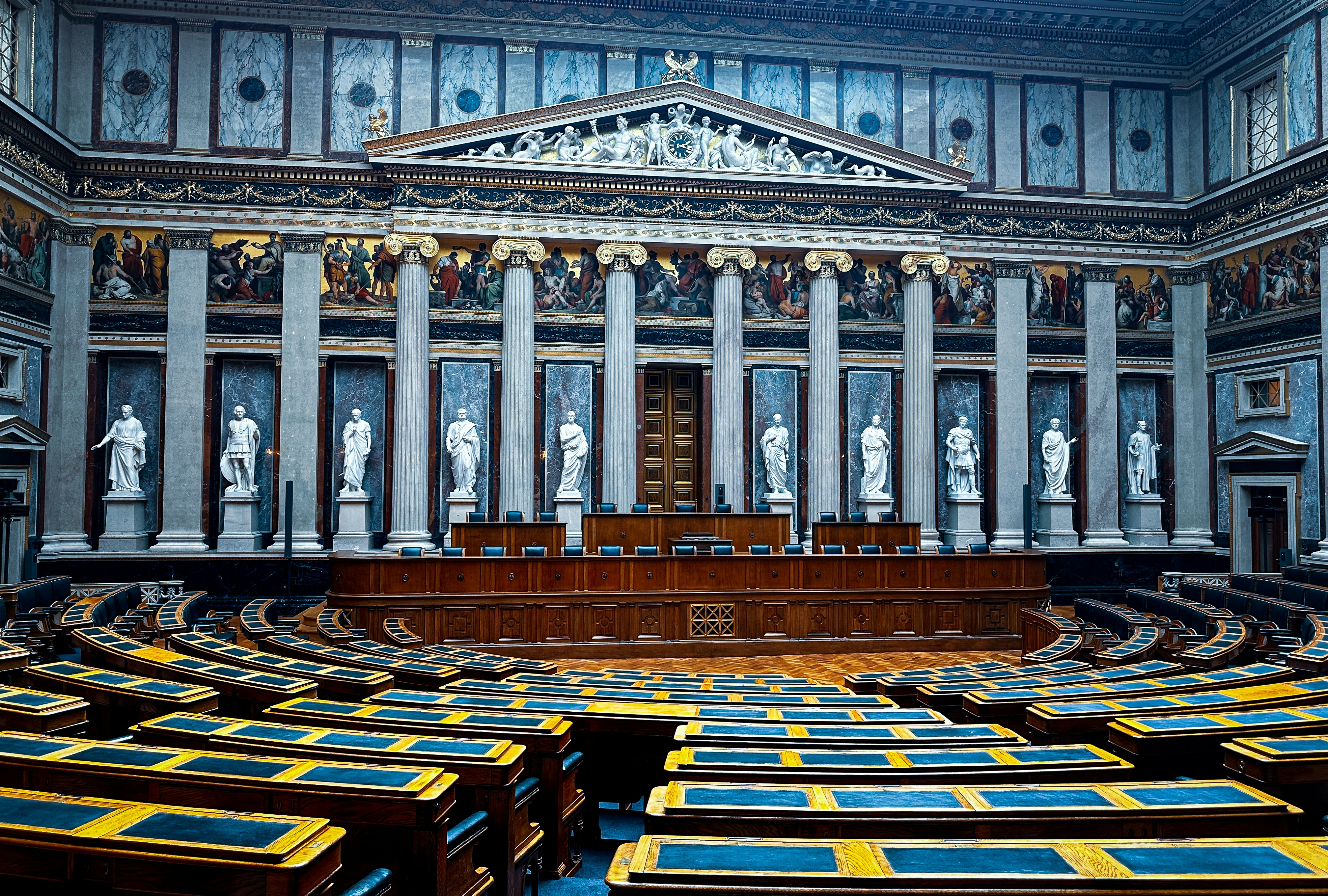 An illustrative photo of a large room filled with lots of wooden chairs