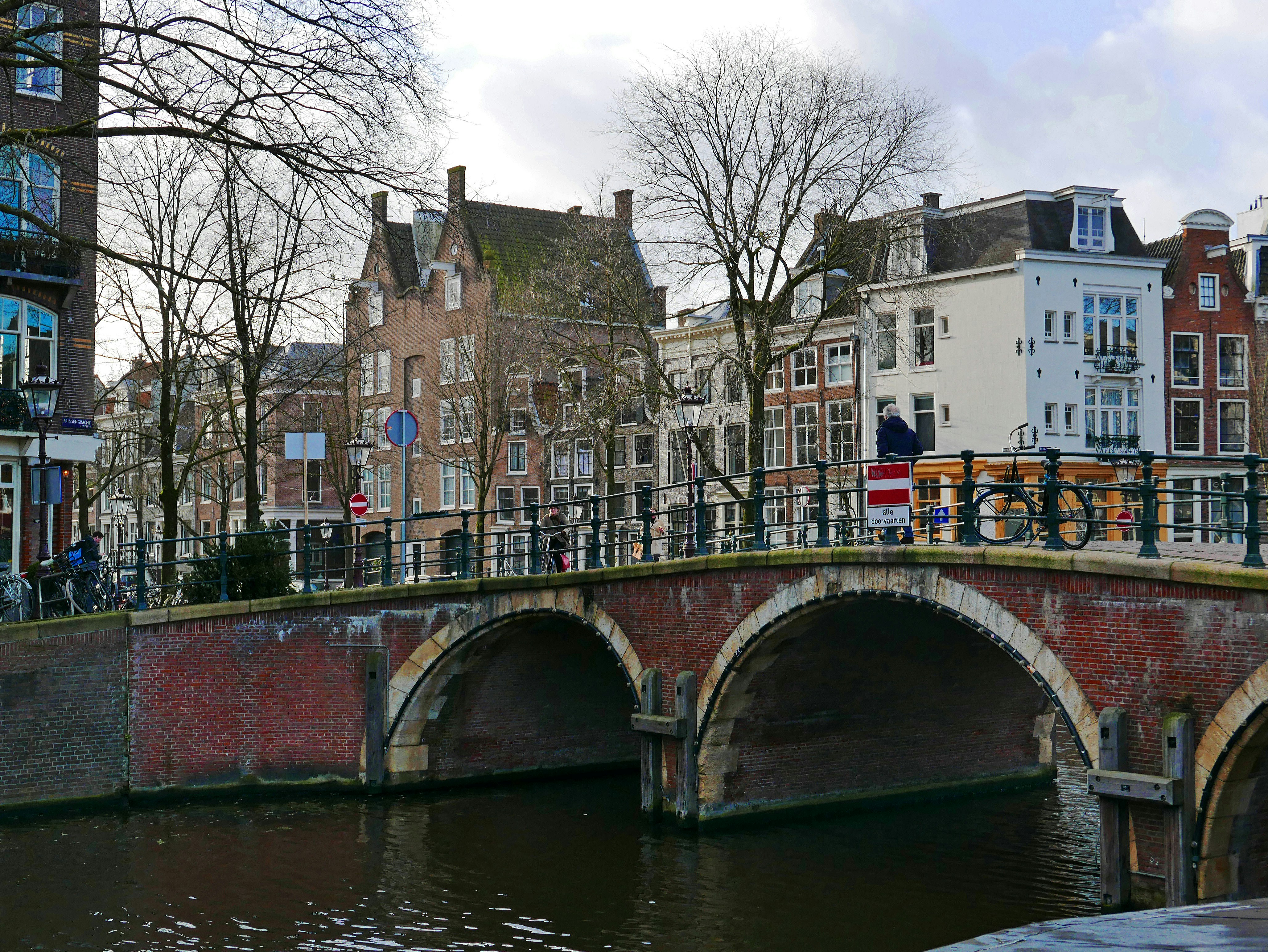 An illustrative photo of a bridge over a river with buildings in the background