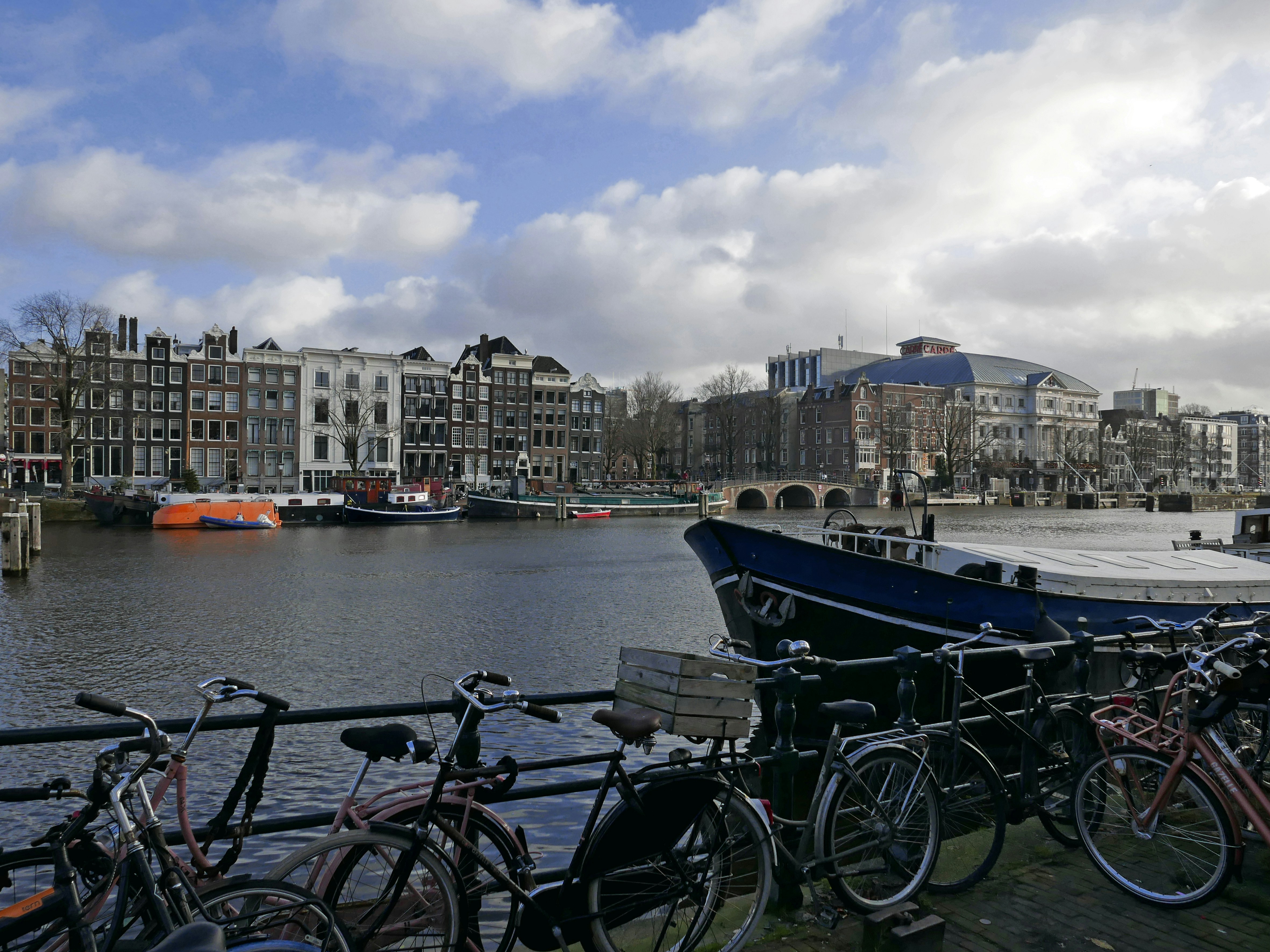 An illustrative photo of parked bikes along the river in Amsterdam