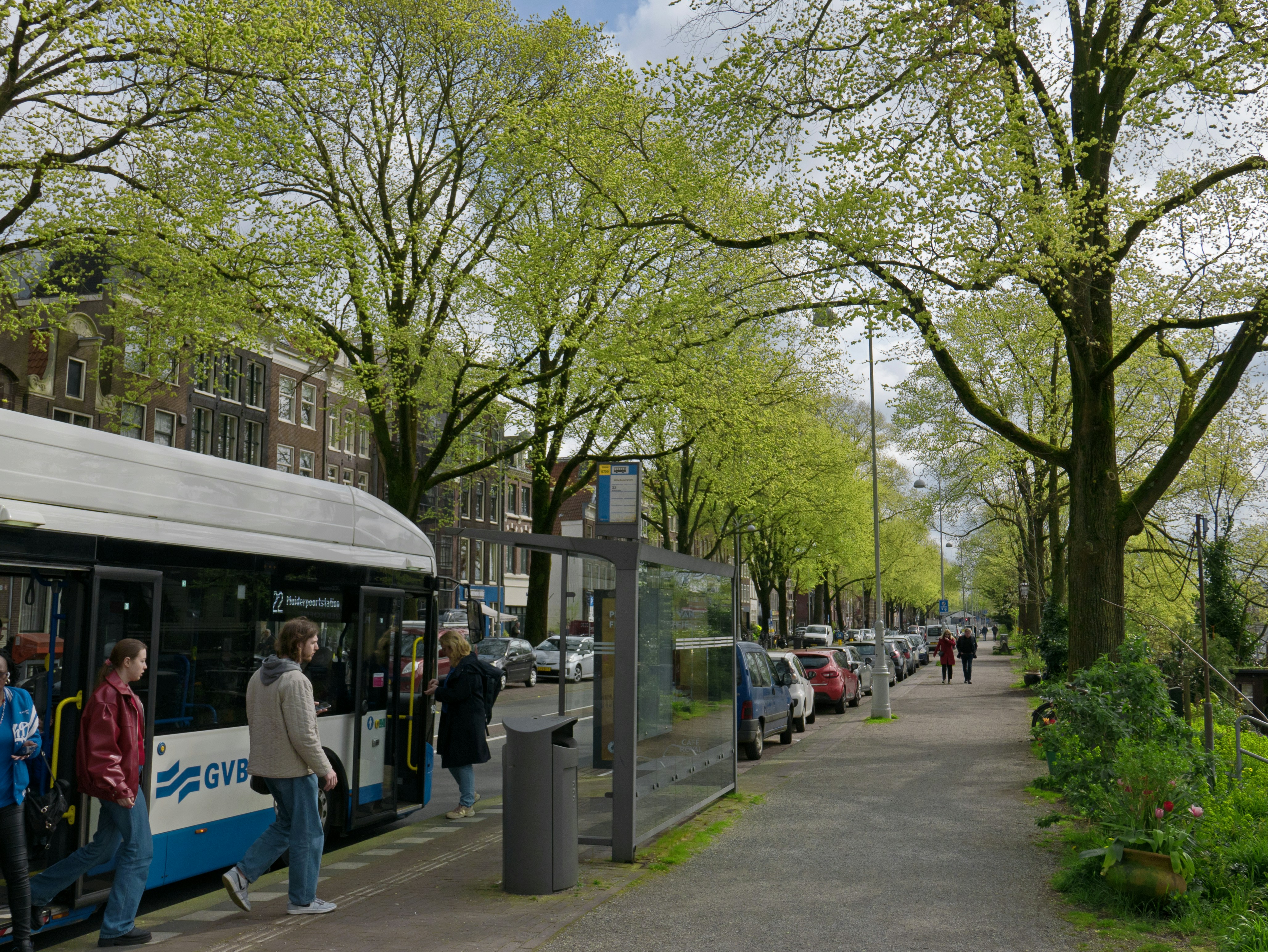 An illustrative photo of a group of people leaving a bus on a green street