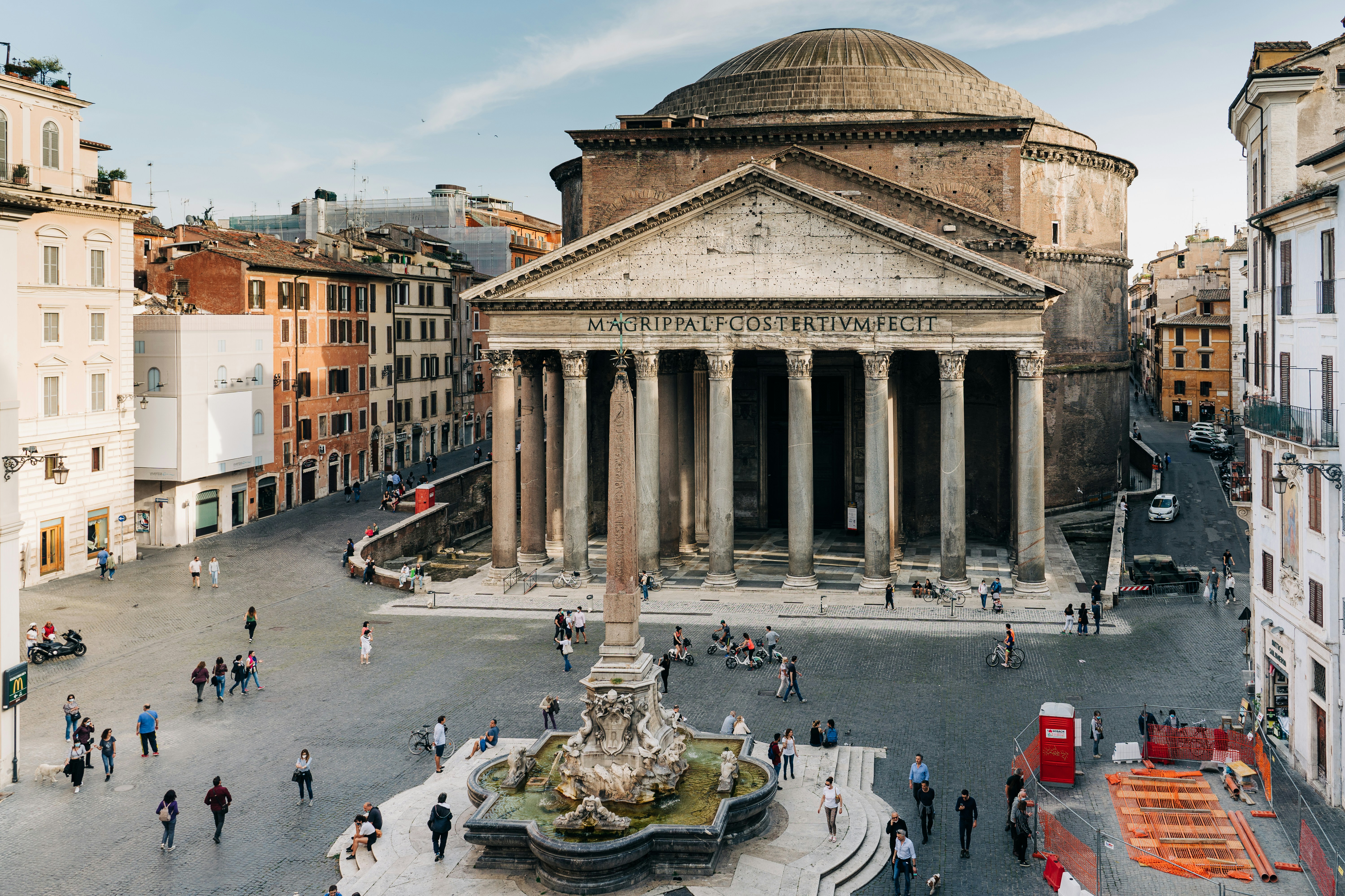 Photo by Unsplash An illustrative photo of people walking near a brown concrete building during the daytime
