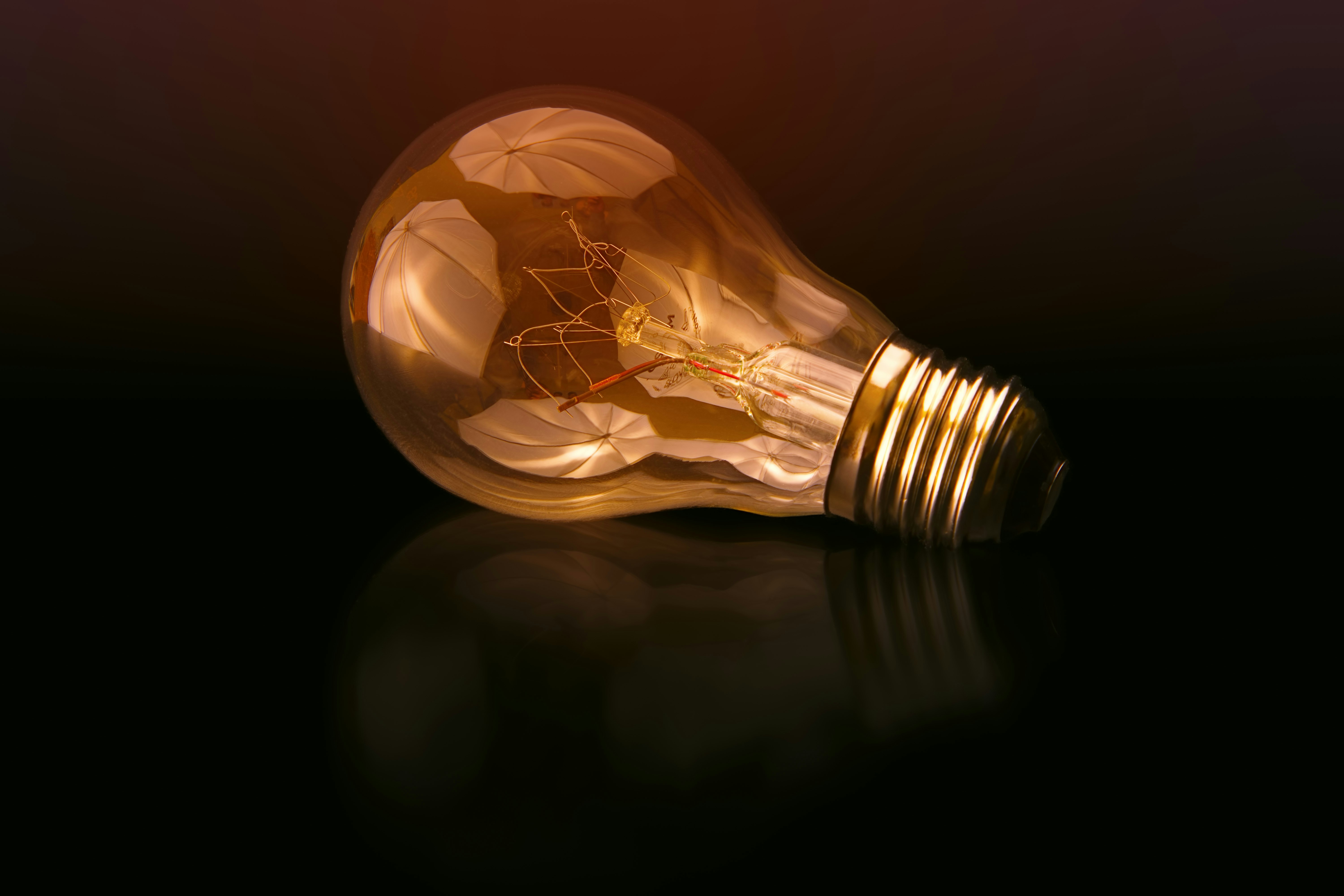 An illustrative photo of incandescent bulb on black surface