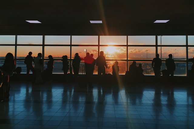 An illustrative photo of  the silhouettes of people inside an airport