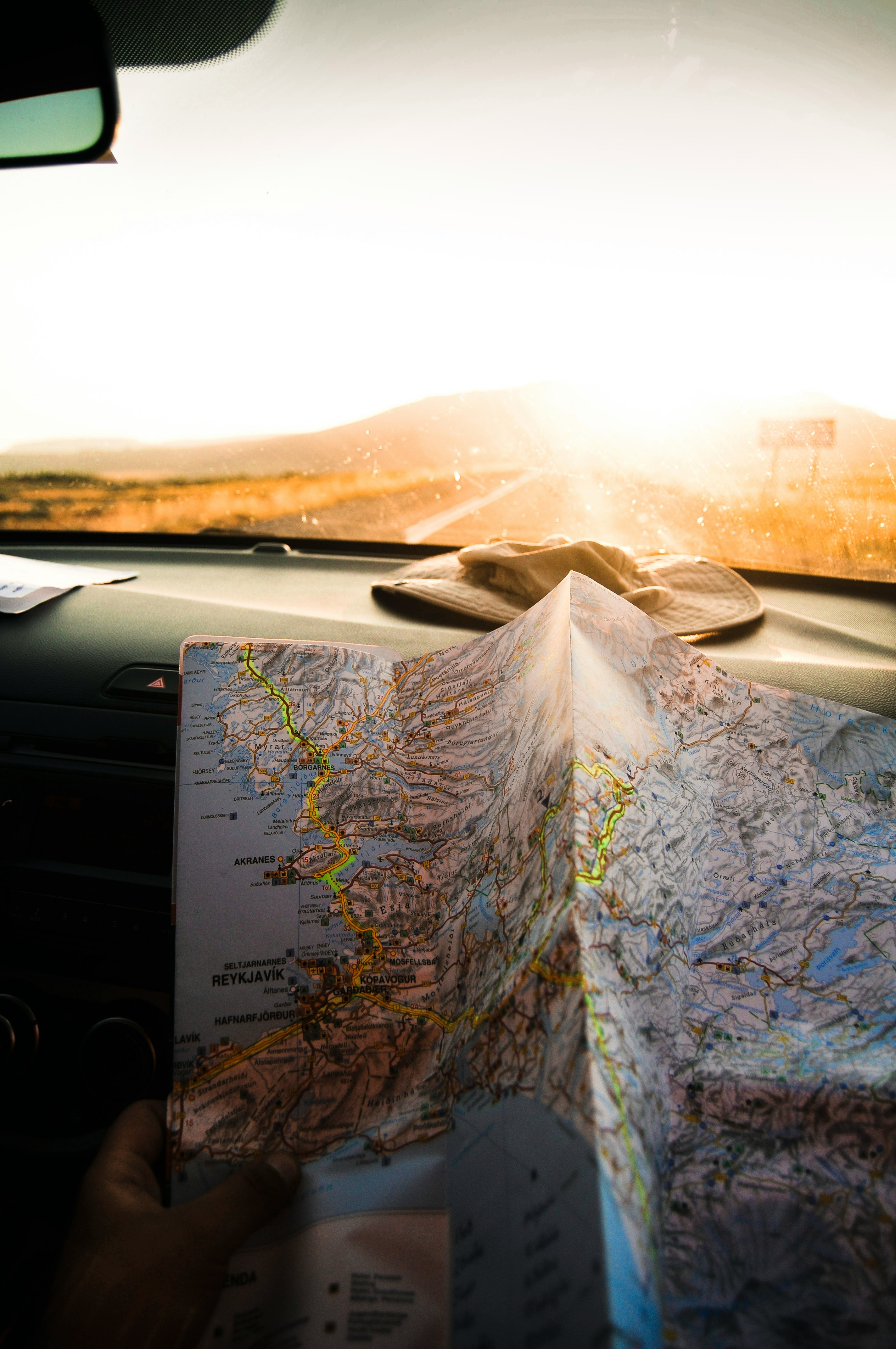 An illustrative photo of a person holding a map in a car
