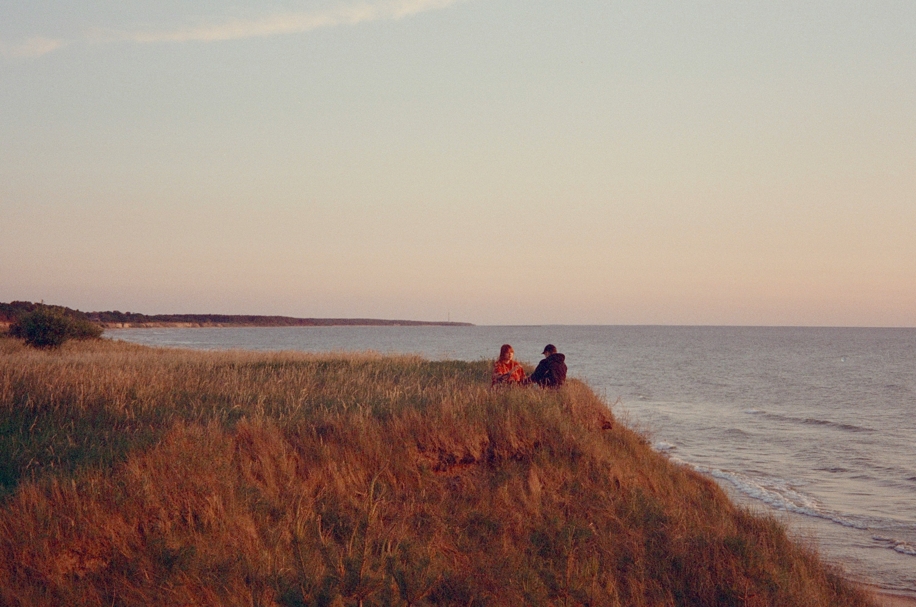 Photo by Unsplash An illustrative photo of people sitting on top of a grassy hillside.