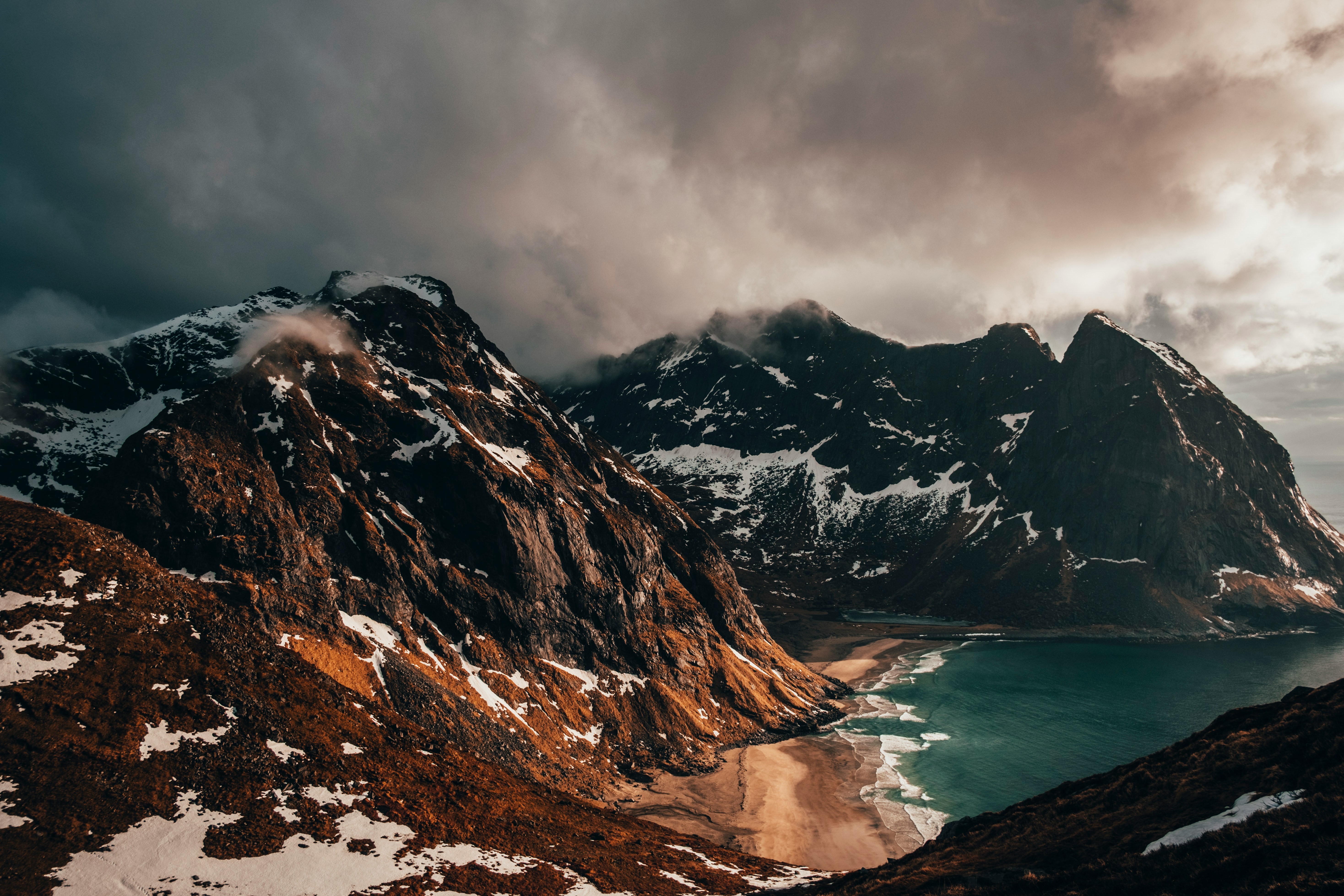 An illustrative photo of brown mountain in snow across water