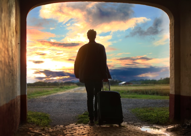 An illustrative photo of a man holding luggage, ready for his journey