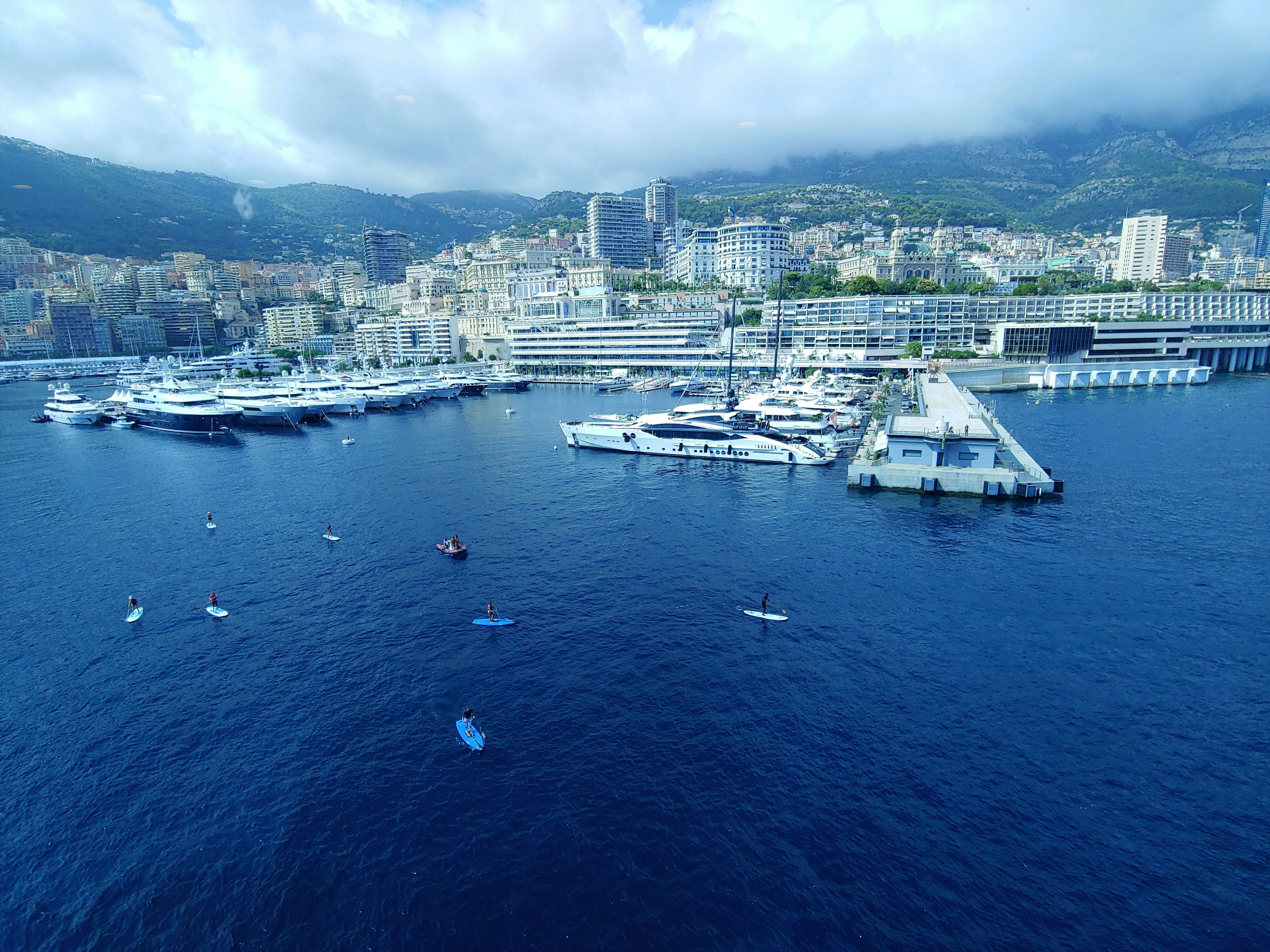 An illustrative photo of a big city near the body of water with boats near the coast