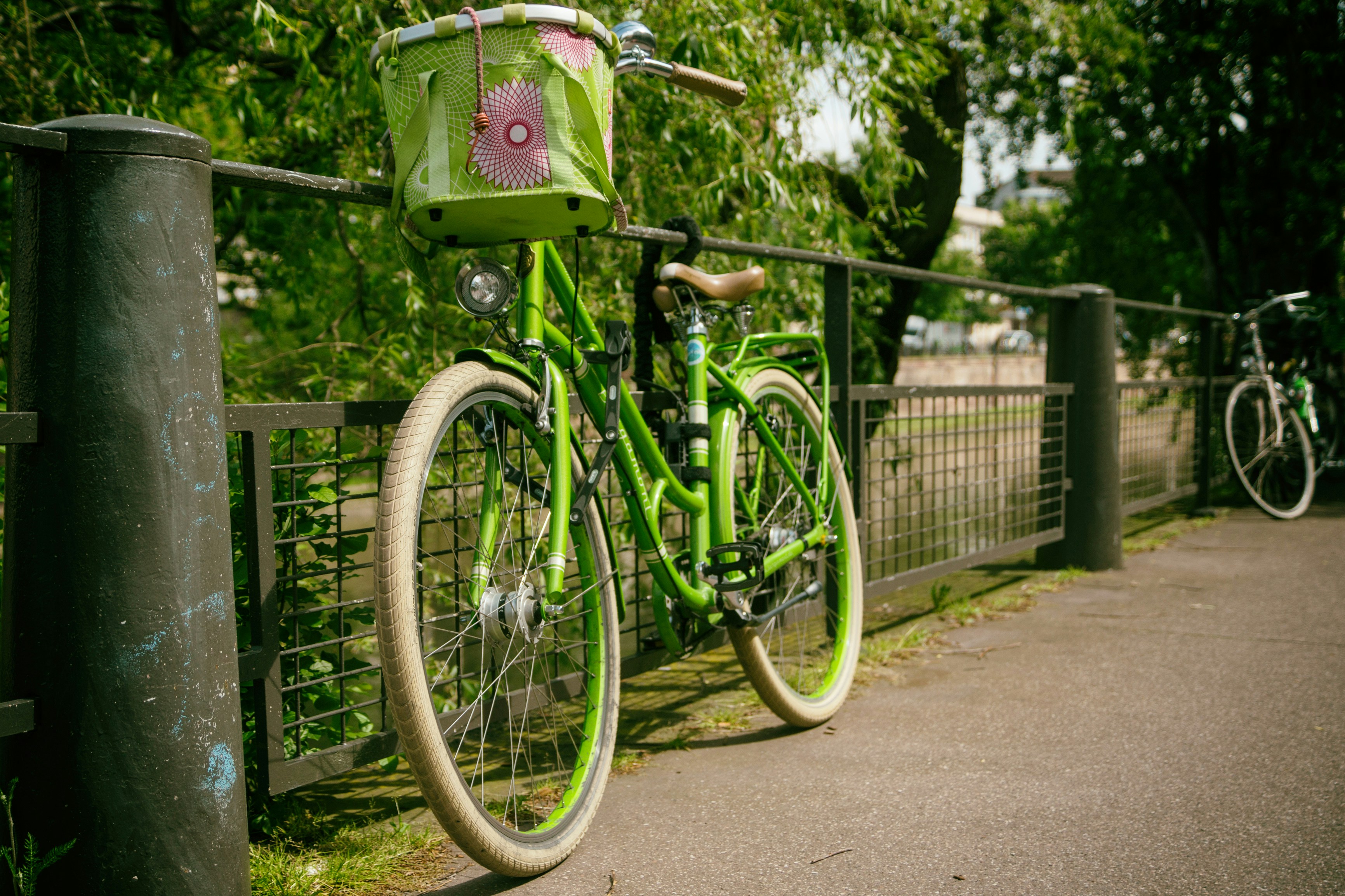 Photo by Unplash An illustrative photo of a green cruiser bike with a basket leaning on a gray rail