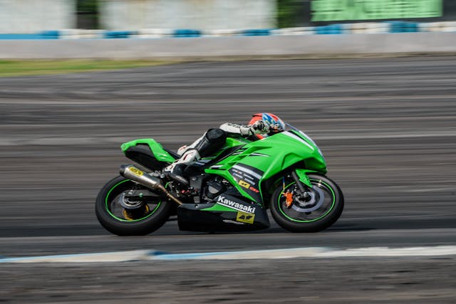 An illustrative photo of a man rides a green sports bike