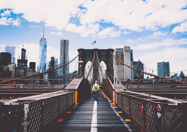 An illustrative photo of a man strolling across a bridge, enveloped in the serene ambiance of a foggy morning